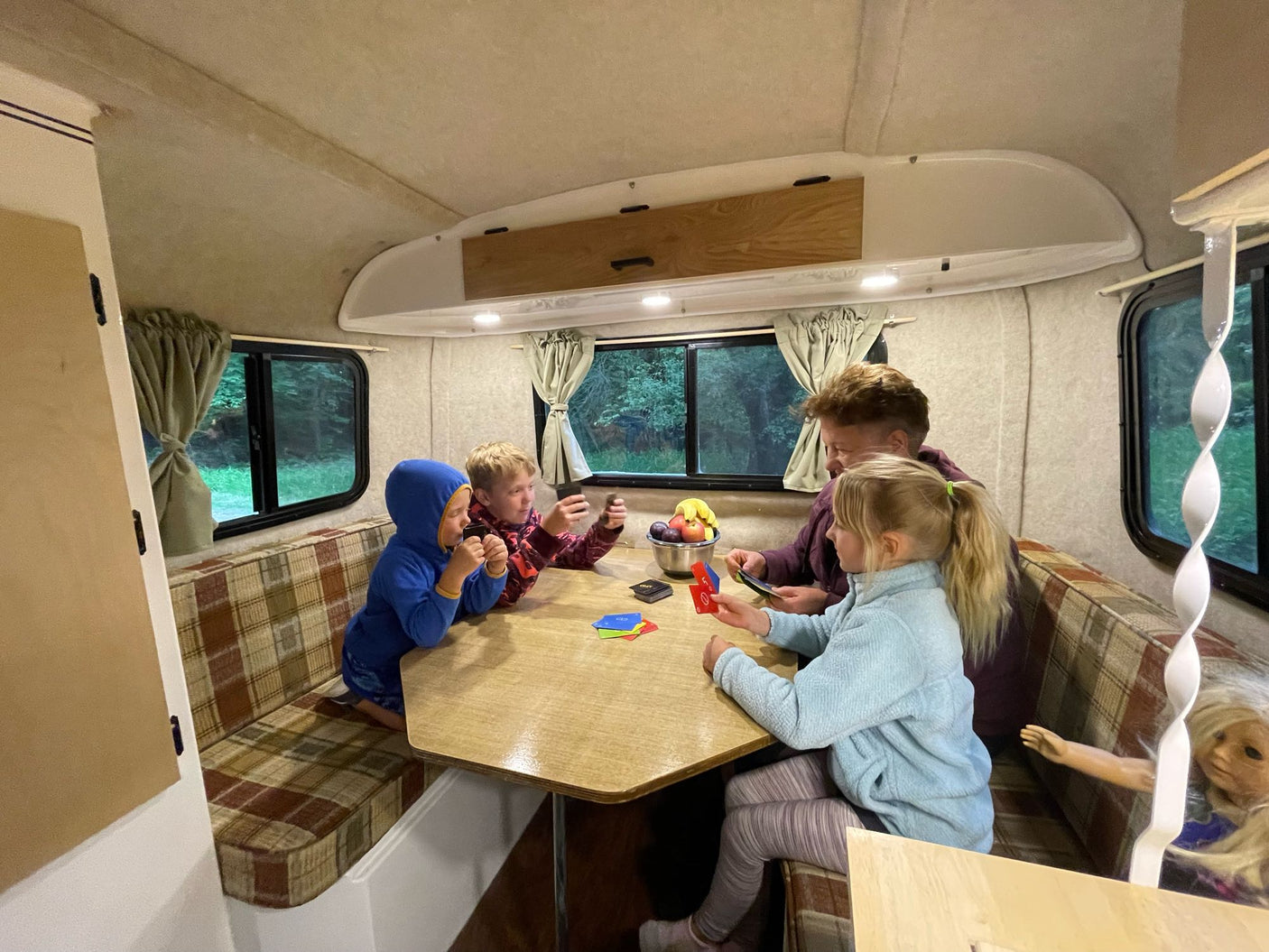 ideal for camping trips.|Small Scamp RV rental set up at a wooded campsite with an awning