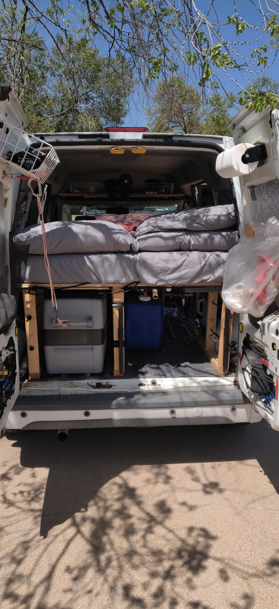 Rear view of a cozy camper van interior with bed, toilet, and water tank, perfect for an rv rental adventure. — photo 10