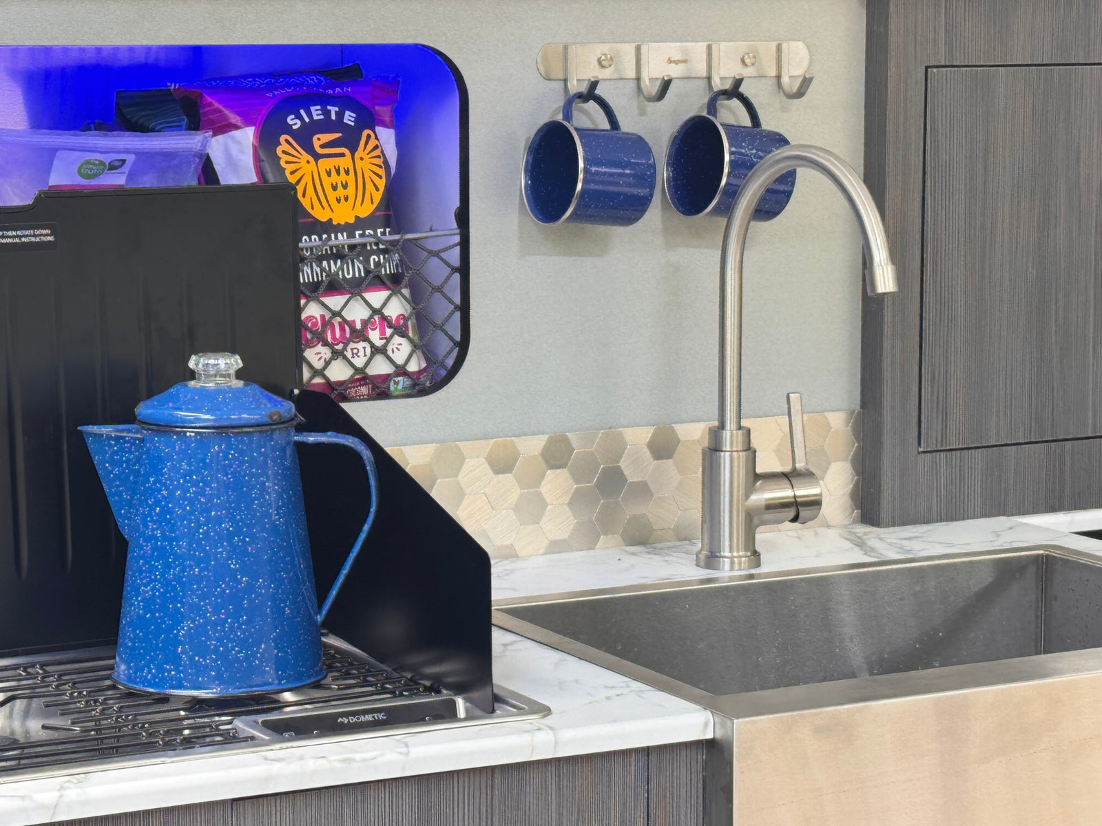 and blue ambient lighting for relaxing travels.|Cozy RV rental interior: Built-in benches with marble tops