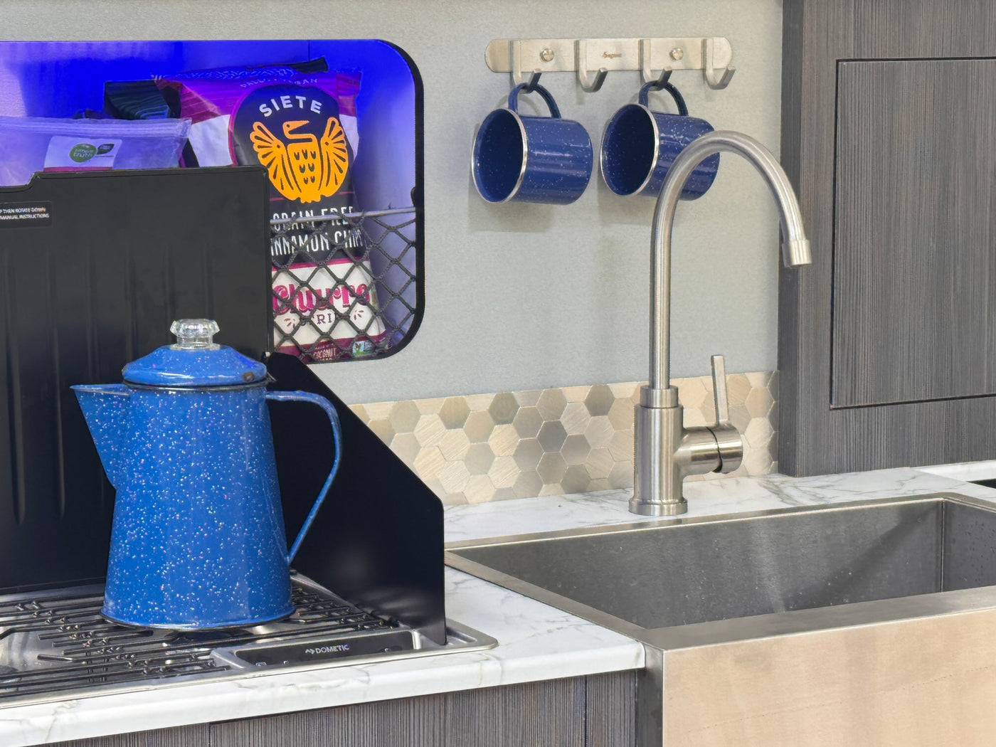 and blue ambient lighting for relaxing travels.|Cozy RV rental interior: Built-in benches with marble tops — photo 11