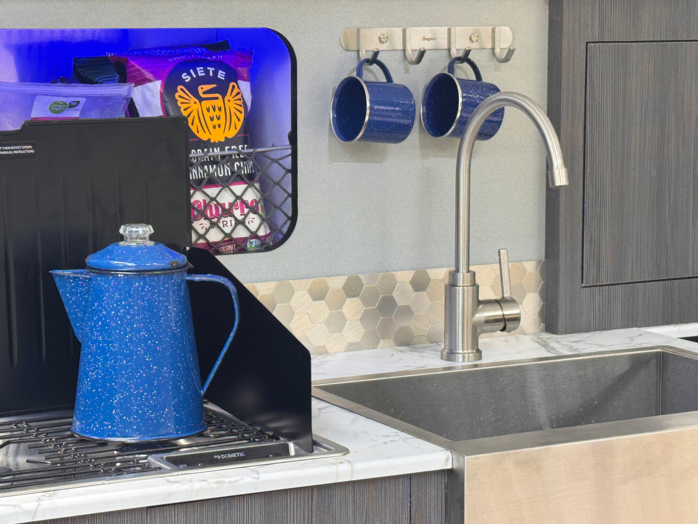 and blue ambient lighting for relaxing travels.|Cozy RV rental interior: Built-in benches with marble tops
