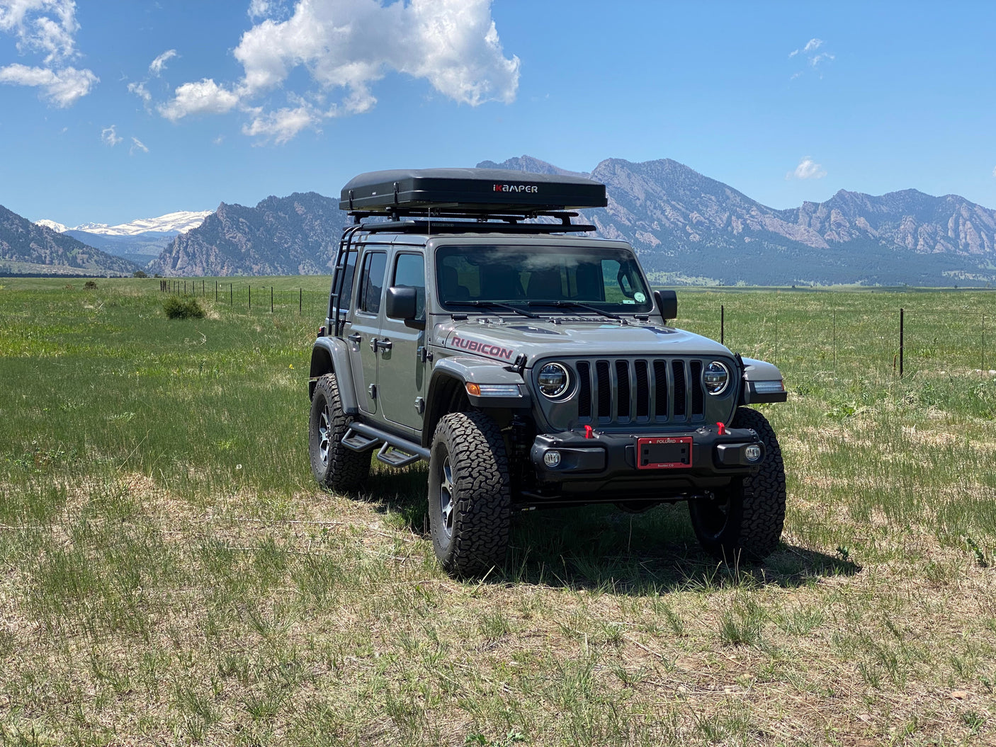 Grey Jeep Wrangler with roof-top tent, perfect for an rv rental and exploring scenic mountain landscapes.