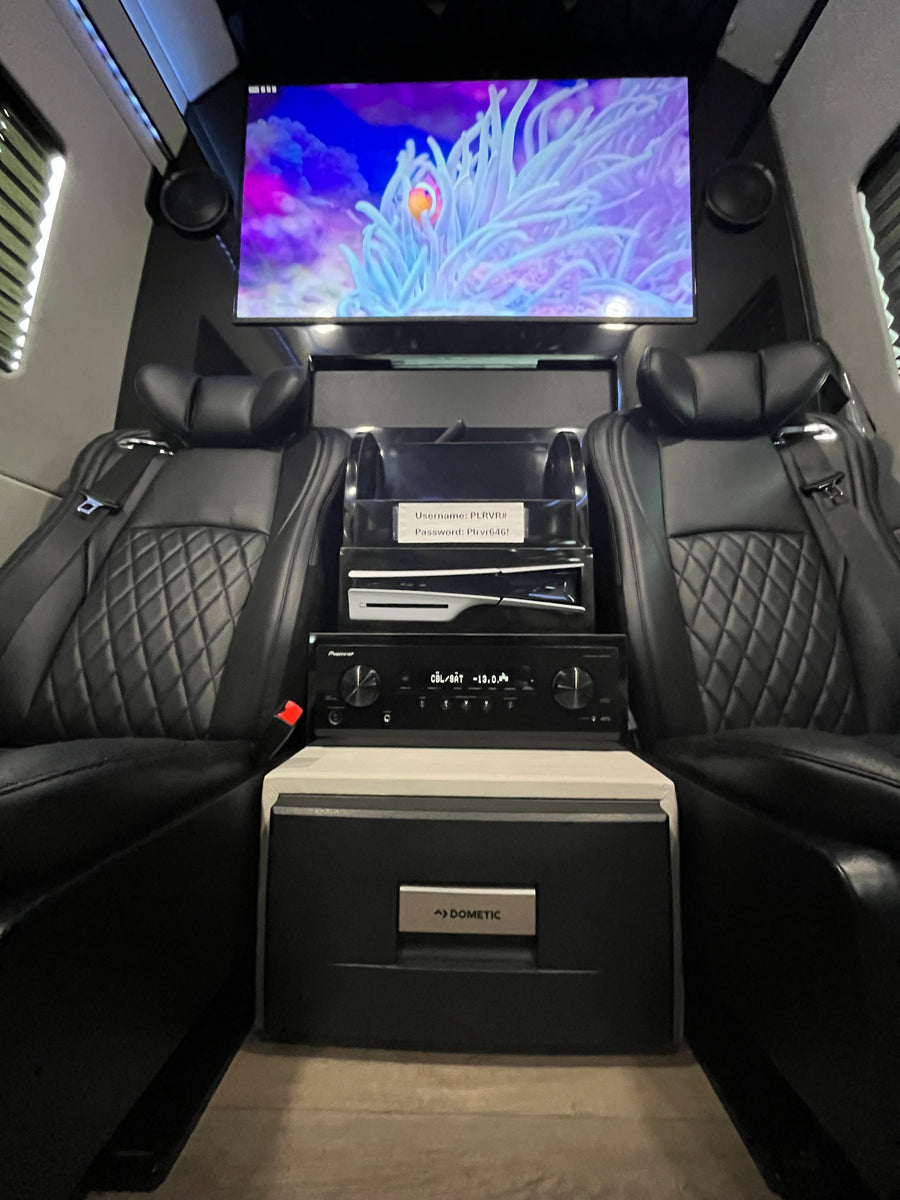 Luxury rv rental interior with black leather seats, TV (clownfish), PS5, Pioneer audio, Dometic fridge. Login: PLRVR#, Plrvr646!