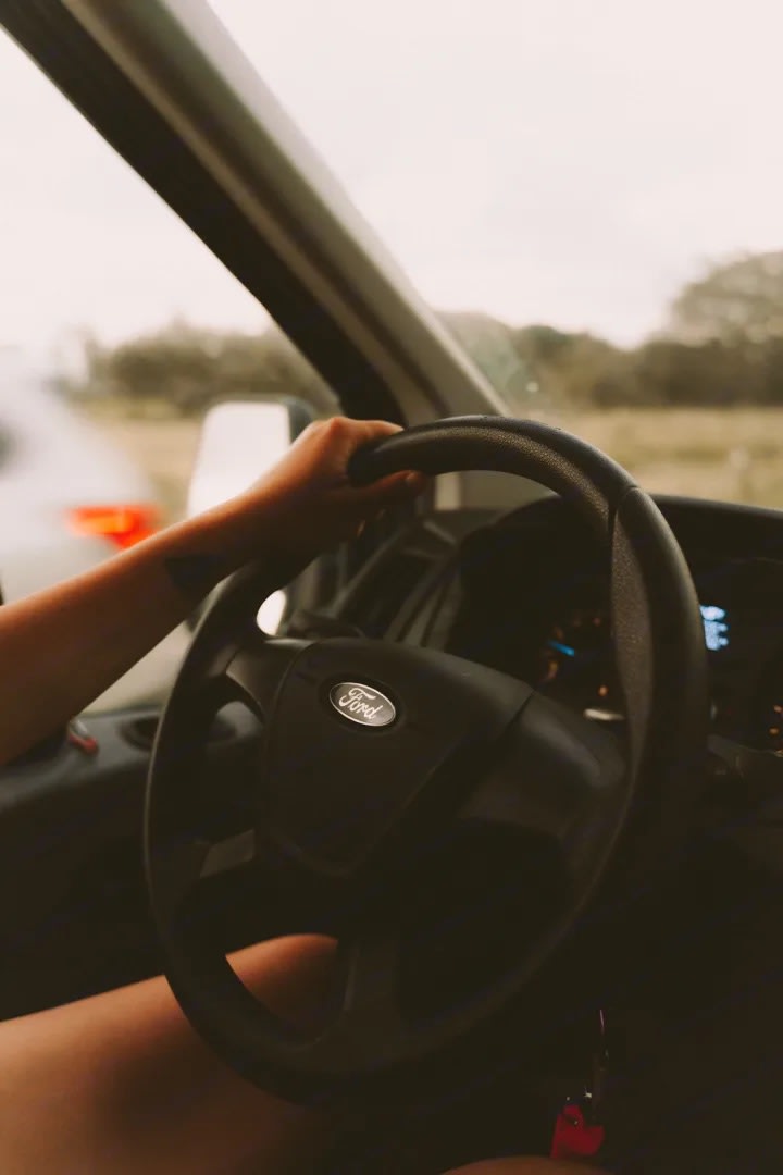 Driving a Ford van, perfect for an RV rental road trip. Keys in ignition, ready for adventure!