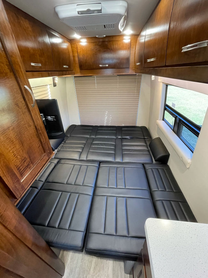 and ample wood cabinetry line the cozy interior.|Inside this modern RV rental