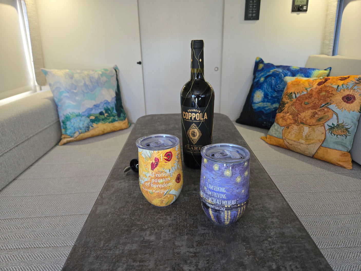 Enjoying wine in an RV rental! Francis Coppola Claret, Van Gogh art tumblers, and pillows create a cozy travel vibe.