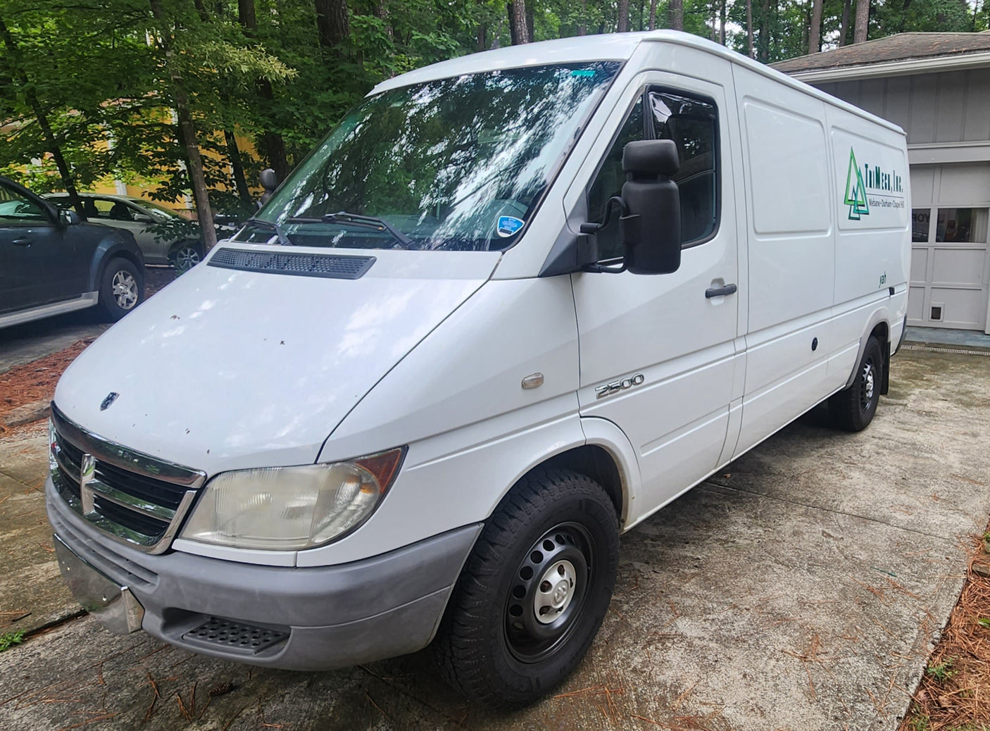 White Dodge Sprinter 2500 van, a spacious option for a DIY RV rental conversion, parked on a concrete driveway.