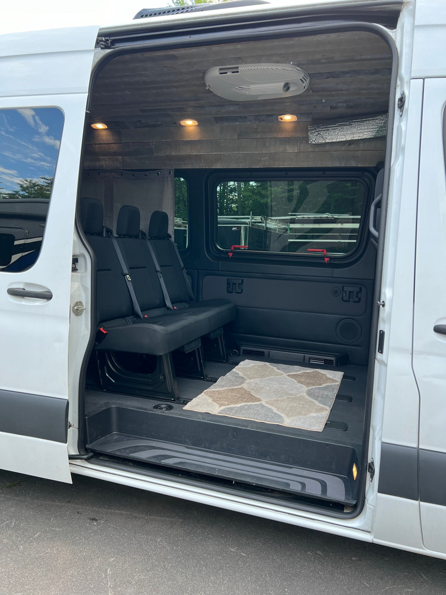 Spacious RV rental interior with comfortable seating and custom wood ceiling, perfect for travel adventures.
