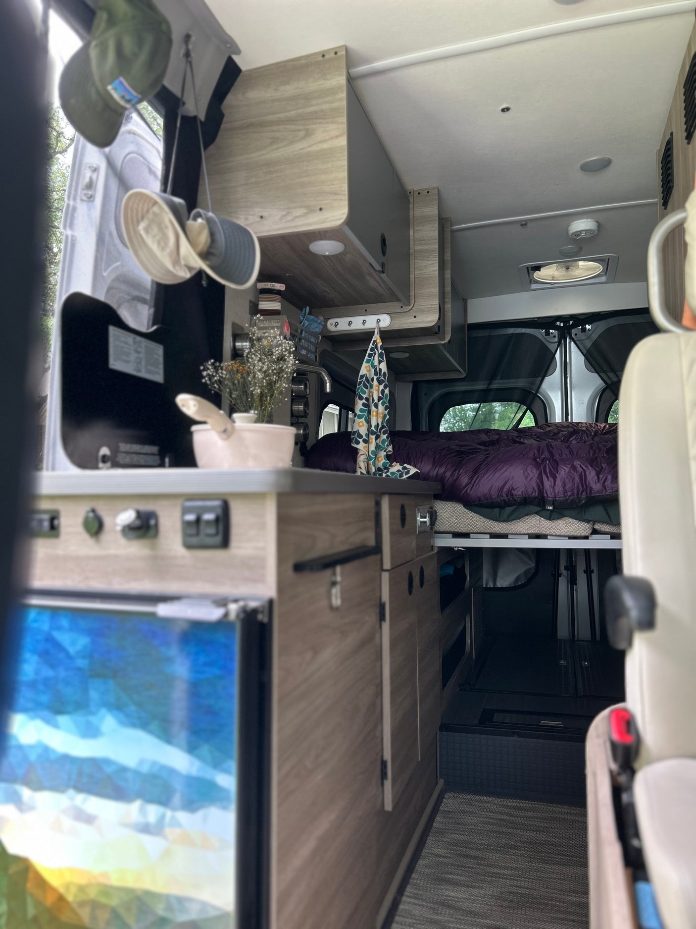 RV rental interior featuring a compact kitchen, bed, and smart storage solutions for cozy travels.