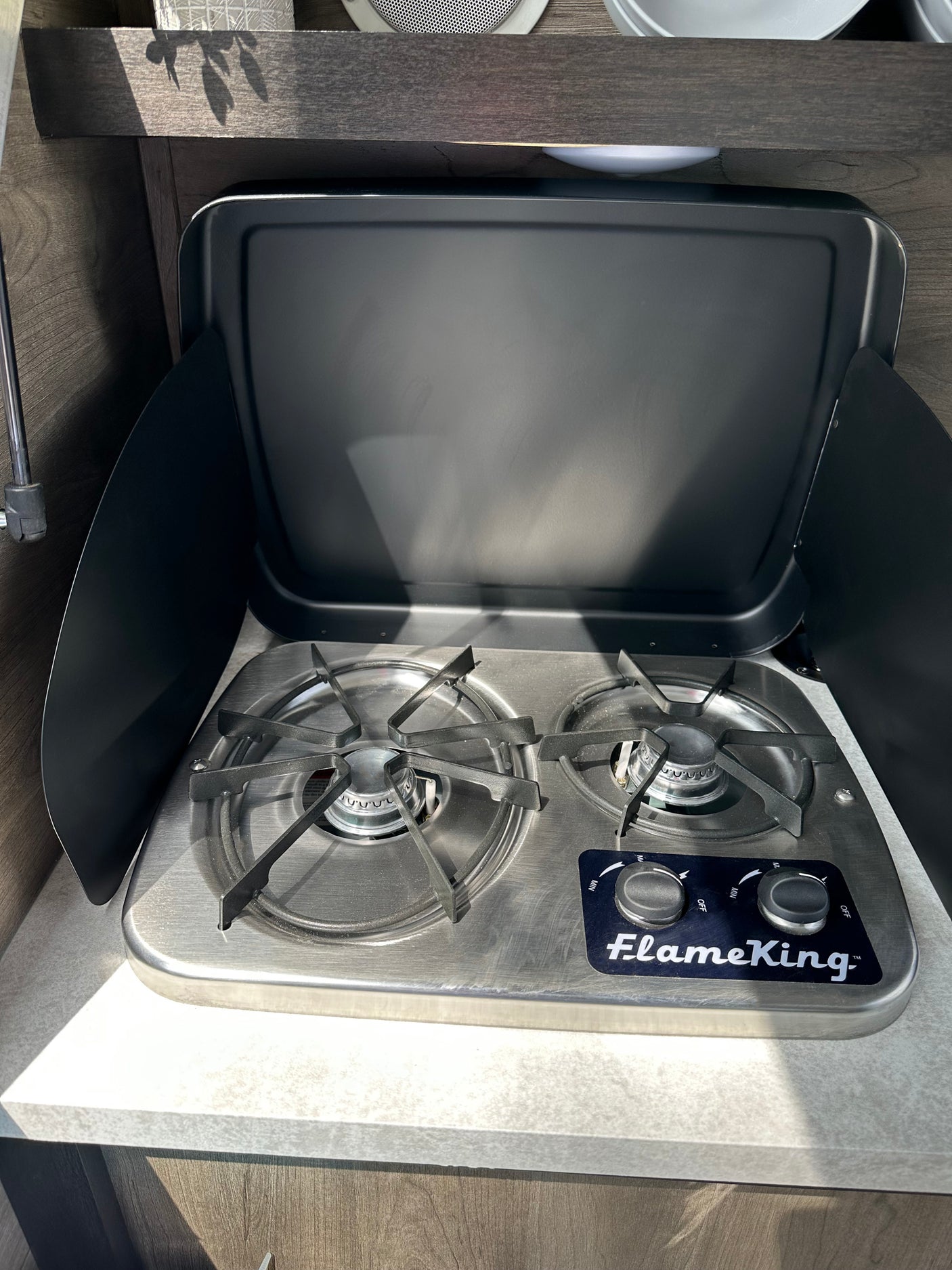 FlameKing two-burner gas cooktop in an RV rental kitchen, ready for camping meals on the go.