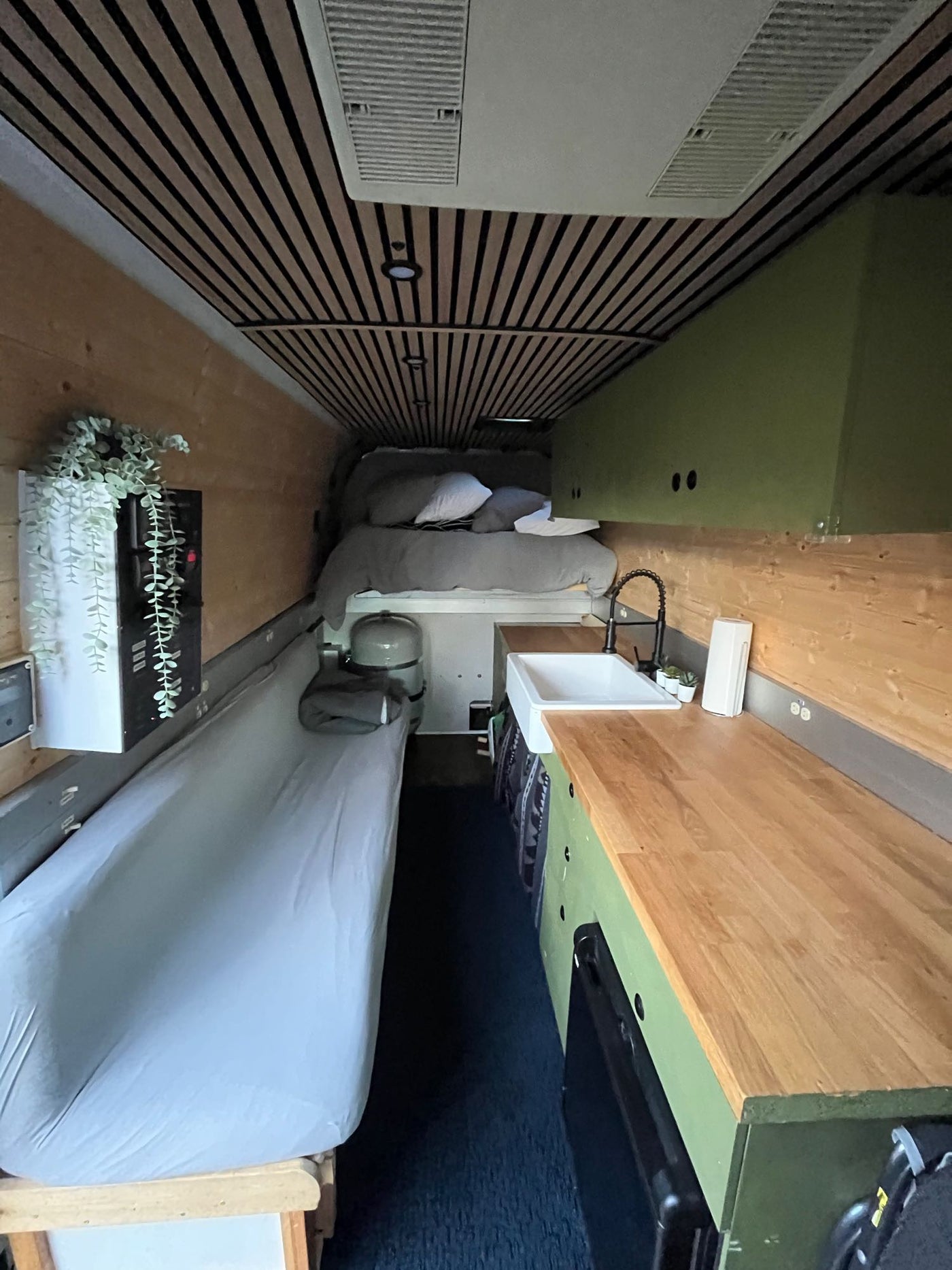 showing clean shelves and door storage.|Golden retriever relaxing on a rug in a pet-friendly RV rental. Baby's car seat also visible in the cozy camper.|An RV rental camper van — photo 5