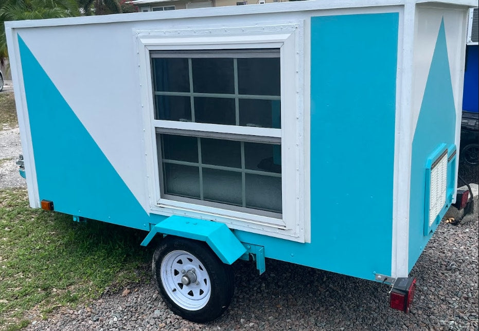 a versatile option for RV rental services.|Bright blue RV exterior with a white louvered access panel for systems like refrigeration