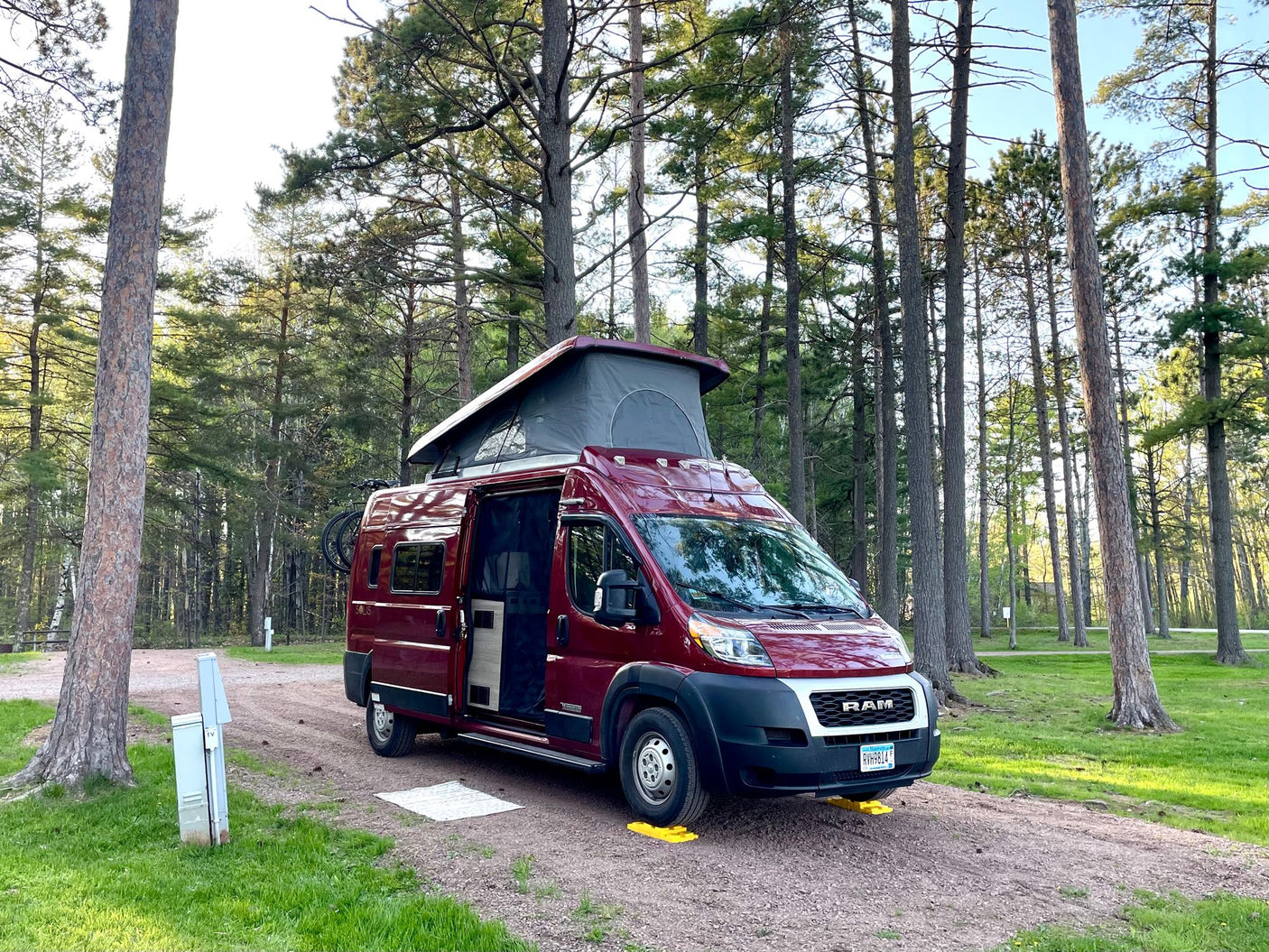 This red **RV rental** is perfectly leveled at a tranquil pine forest campsite