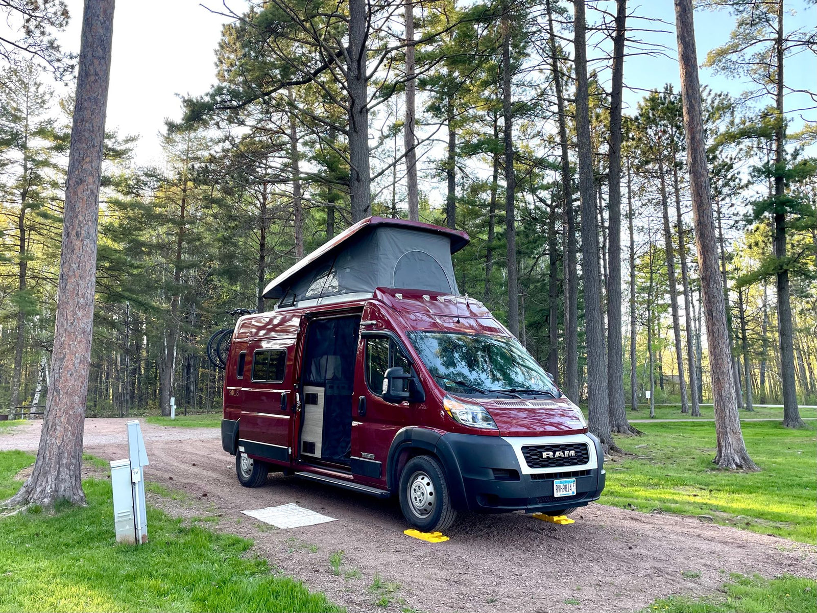 This red **RV rental** is perfectly leveled at a tranquil pine forest campsite