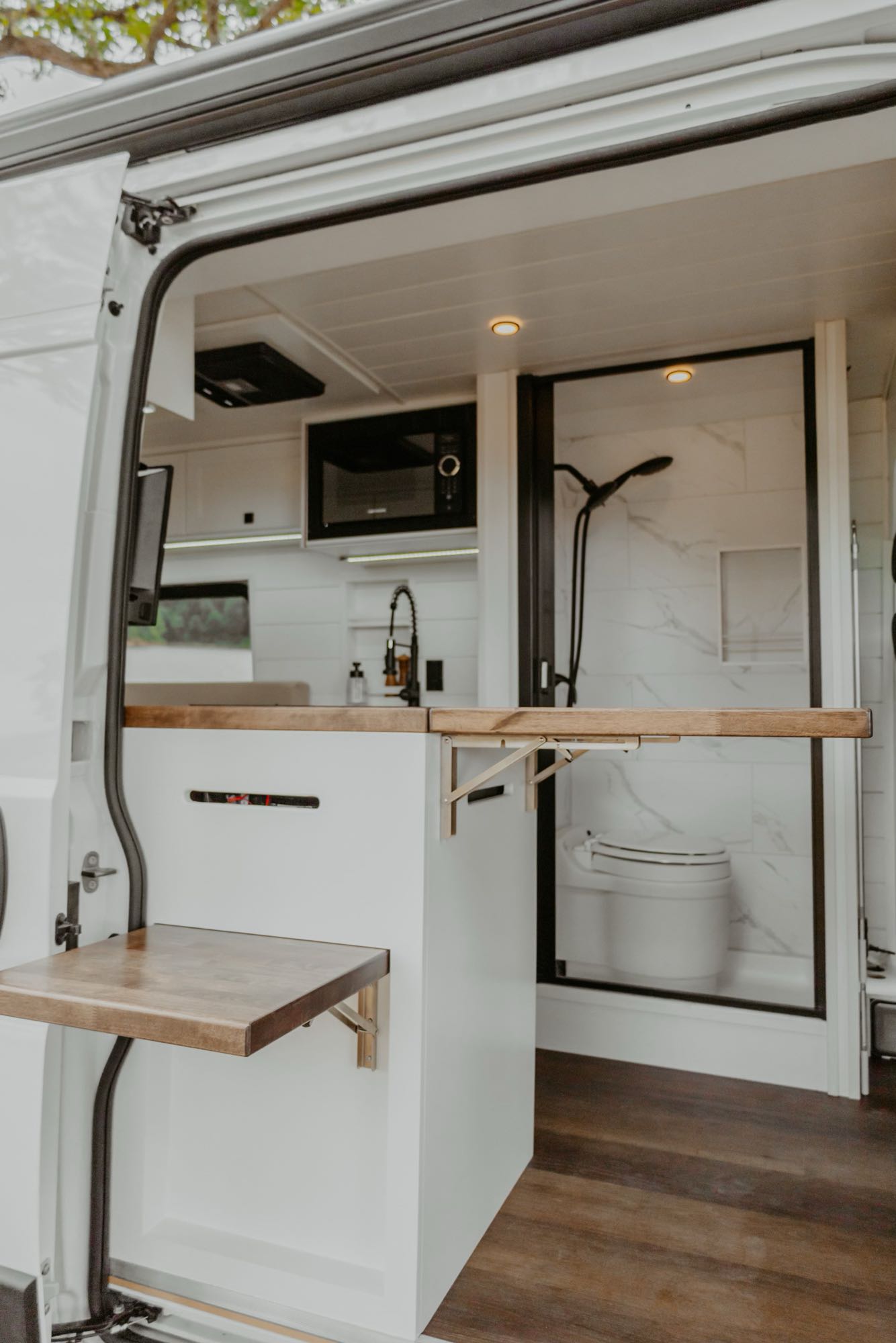 parked by the lake.|Explore in style! This RV rental features a modern camper van interior with a kitchen