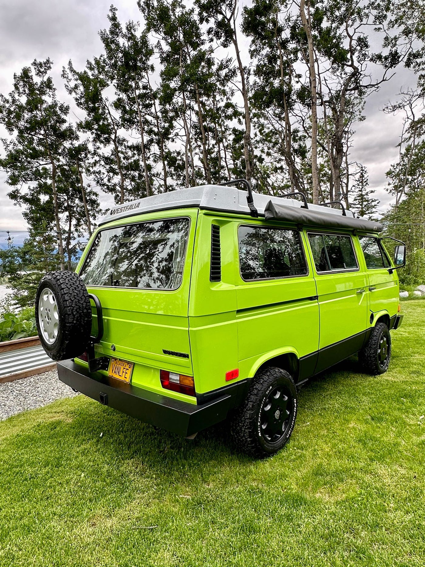 with a green adventure vehicle in the background.|Cozy RV rental: A stack of colorful travel books — photo 15
