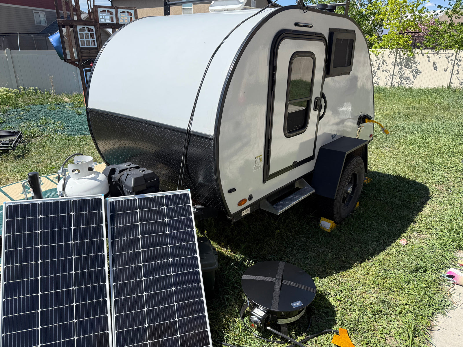 This teardrop trailer **rv rental** features solar panels, propane, and a grill, perfect for off-grid camping.