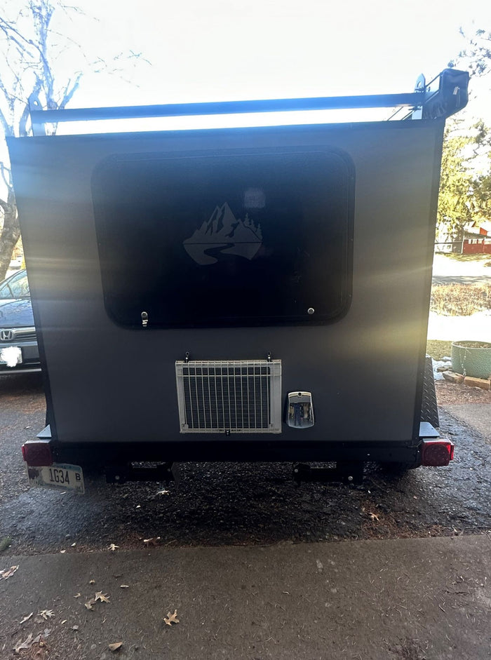 parked on a driveway.|Rugged gray & black enclosed trailer for RV rental