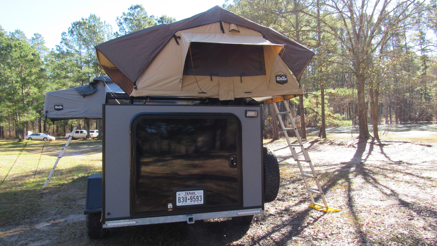 Experience outdoor adventure with an RV rental like this overlanding trailer, featuring a deployed rooftop tent for camping.