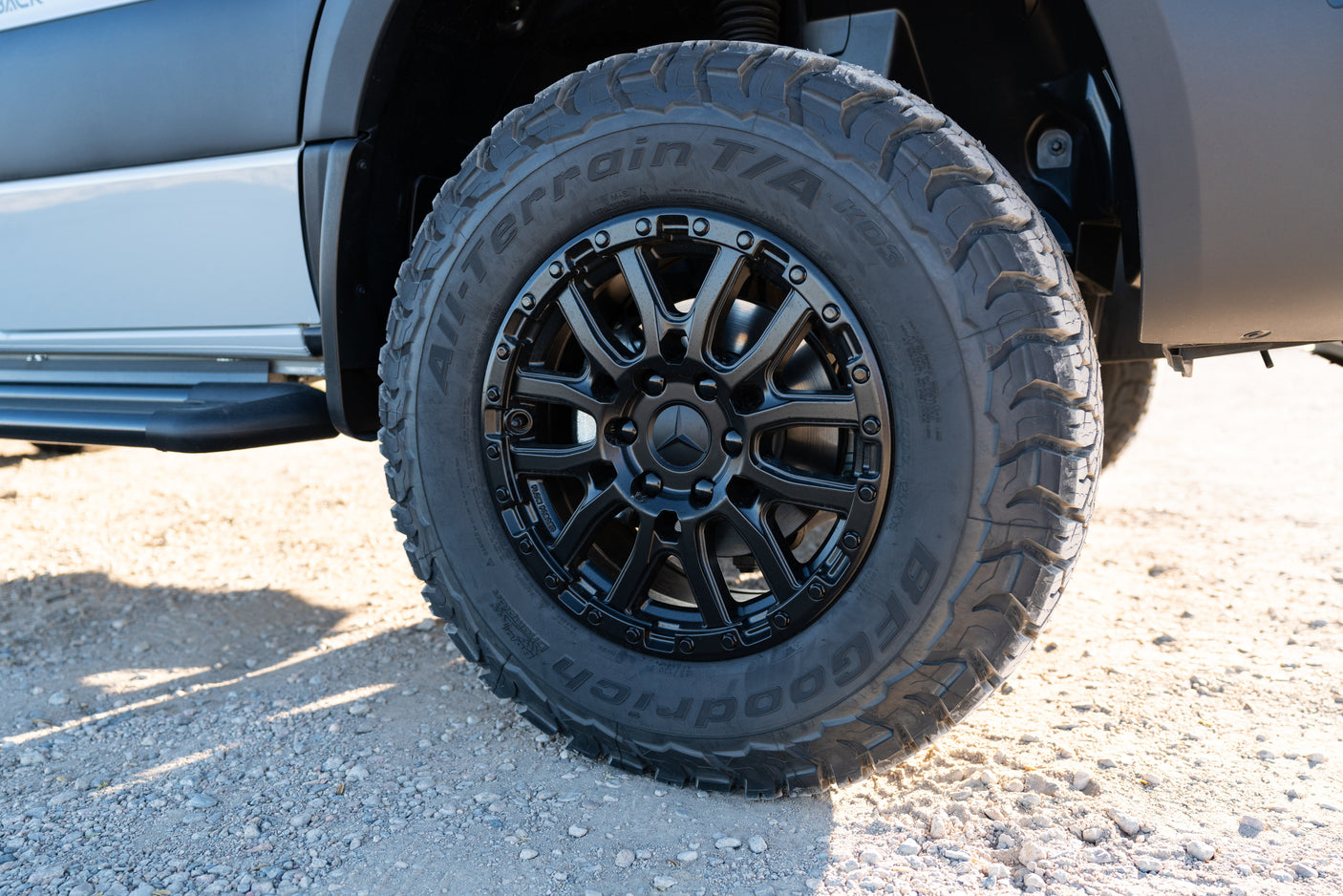 Close-up of a BFGoodrich all-terrain tire and black Mercedes-Benz wheel on an RV rental, ready for adventure.