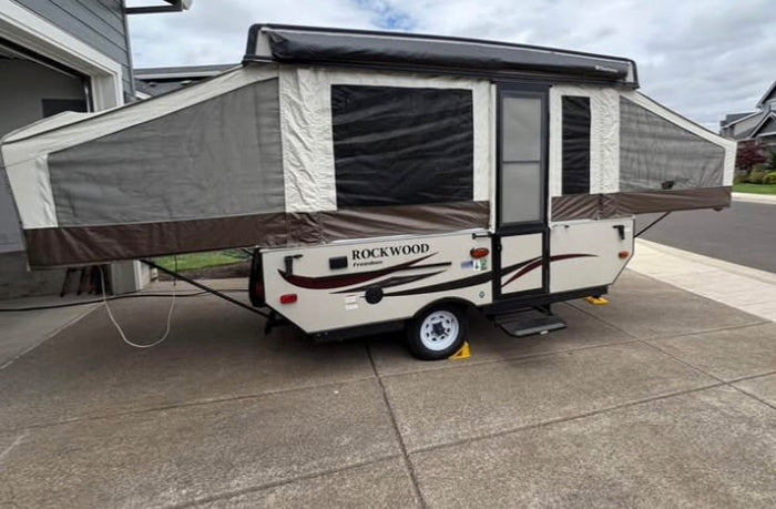 is fully deployed at a sunny forest campsite.|RV rental: Inside a pop-up camper