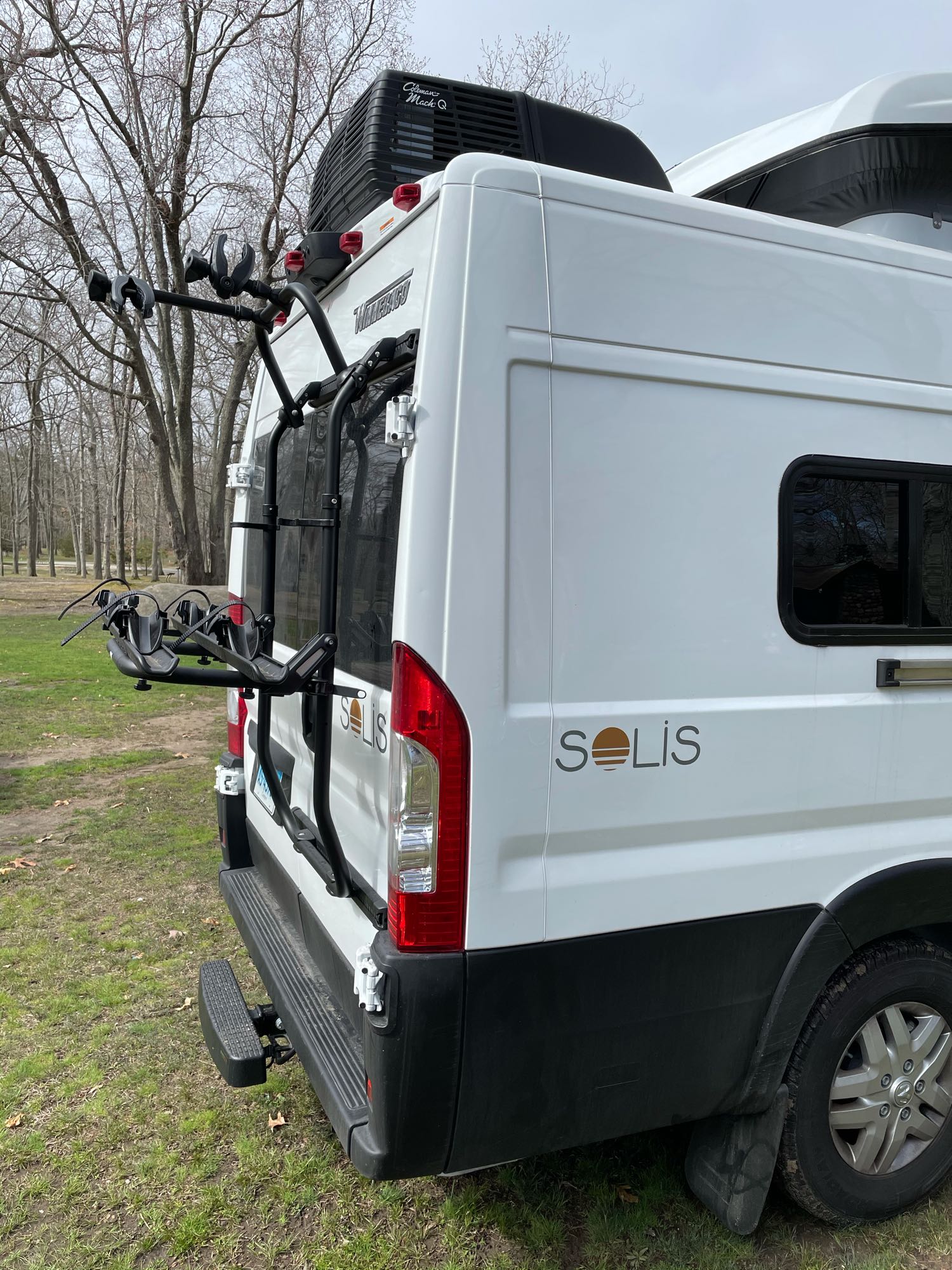 and hinged floor panels for extensive cargo capacity.|RV rental camper van interior: large bed