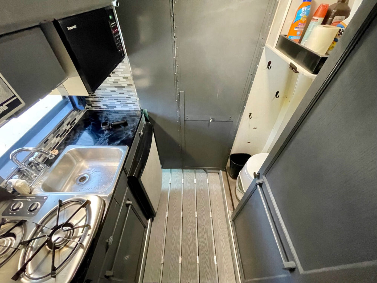 and bed for your next adventure.|An RV rental interior setup: two dark seats