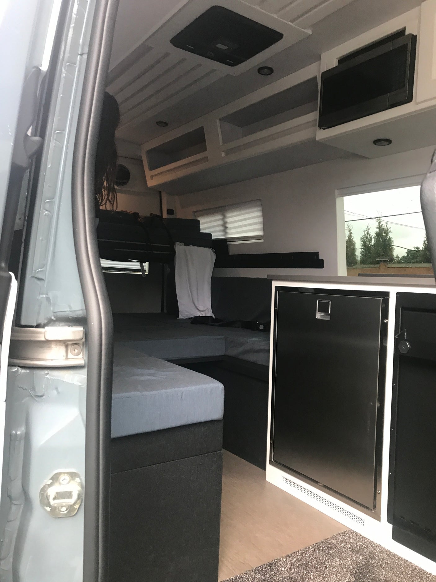 RV rental interior: A cozy camper van with bunk beds, refrigerator, and microwave, perfect for an adventure.