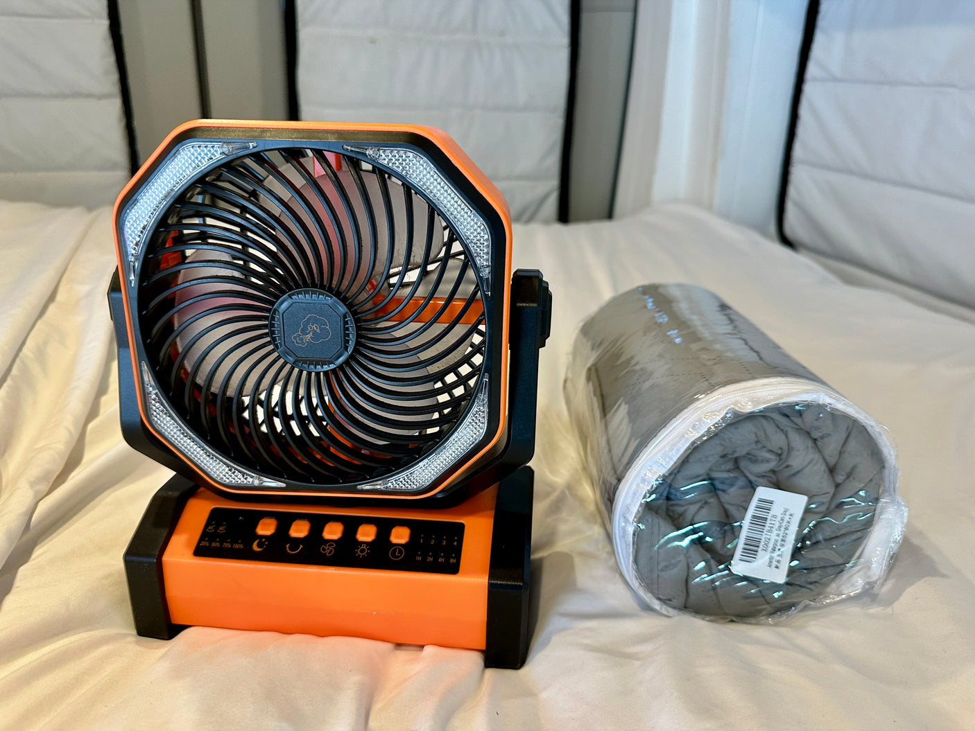 Essential RV rental accessories: a versatile portable fan with lights and a comfy rolled blanket.