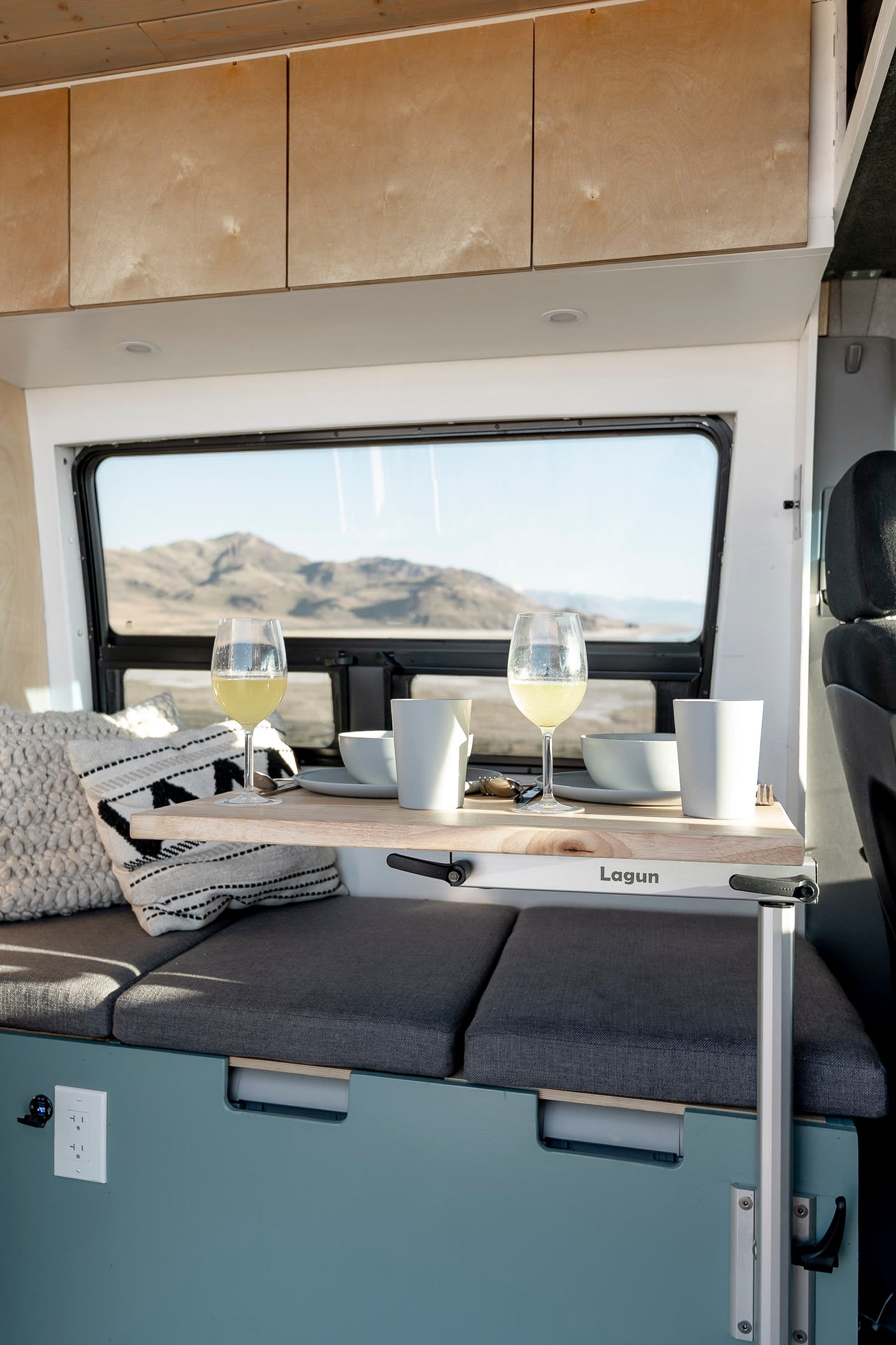 Enjoy the scenic view from this cozy camper van dining area, perfect for your next rv rental adventure. Features a Lagun table.