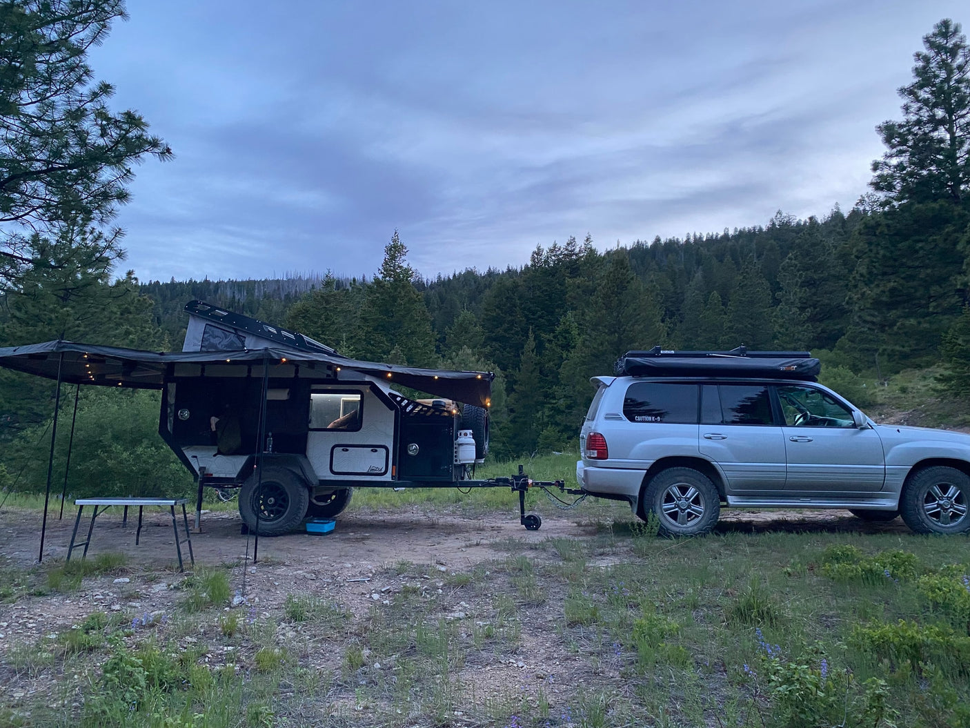 and solar power setup in a lush forest.|Spacious interior of an RV rental annex with camping chairs