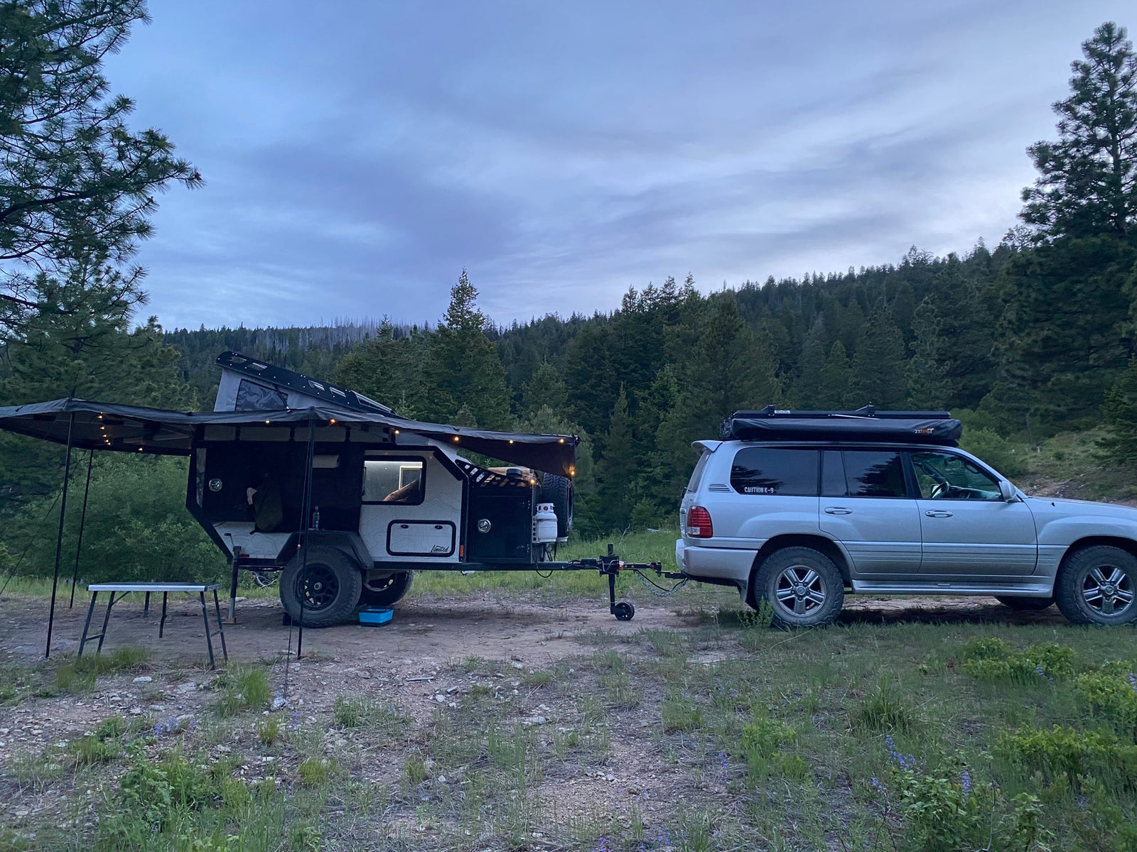 and solar power setup in a lush forest.|Spacious interior of an RV rental annex with camping chairs