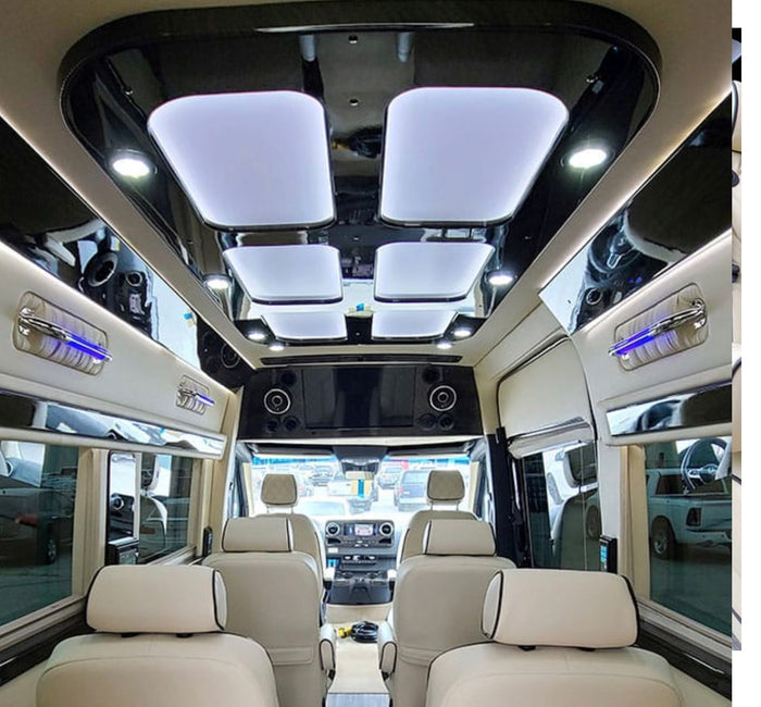 featuring a plush tan interior with side door open.|Experience luxury rv rental with this spacious van interior featuring plush seating