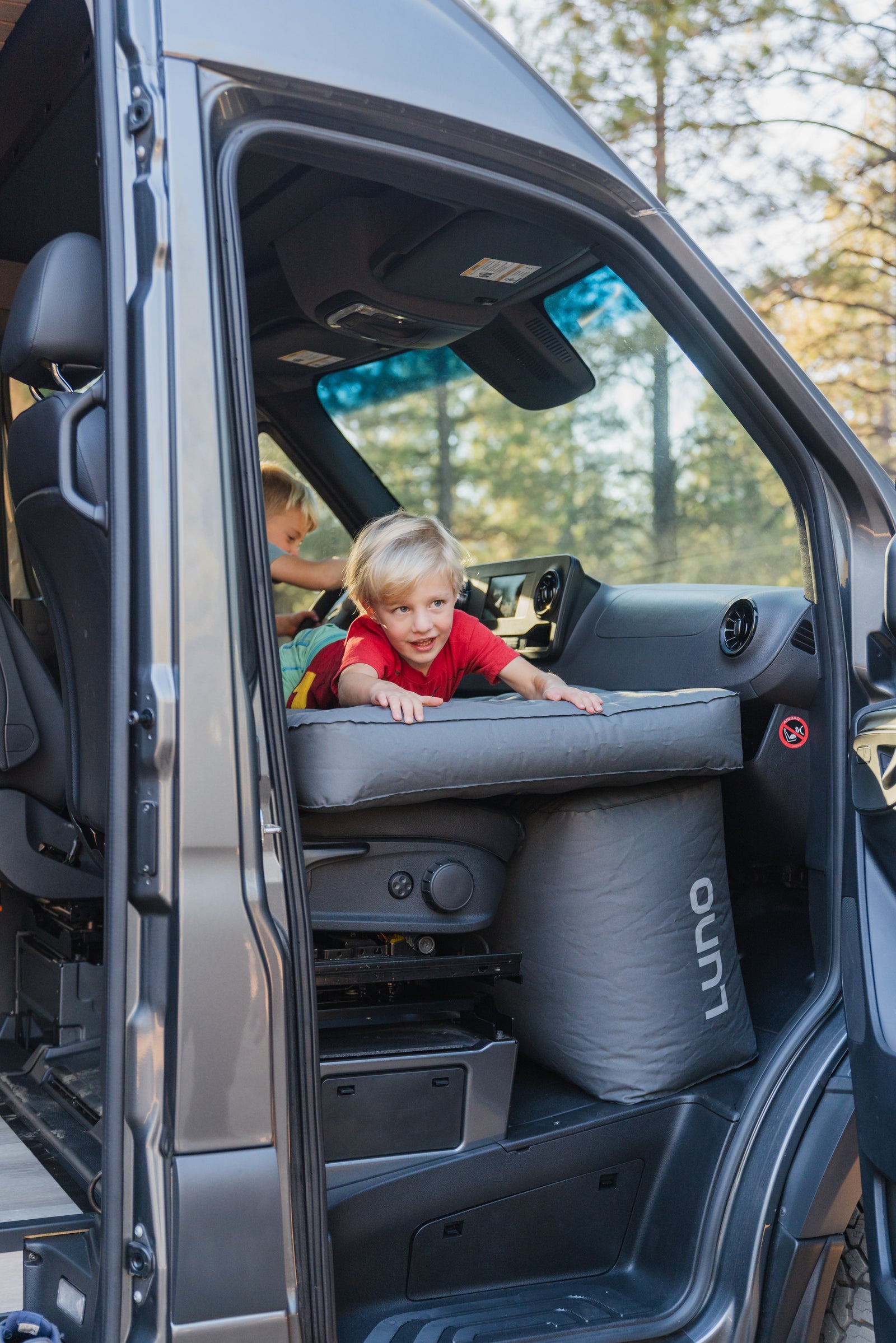 Two boys enjoy an rv rental van's Luno Air Mattress. Ideal for comfy family road trip adventures!