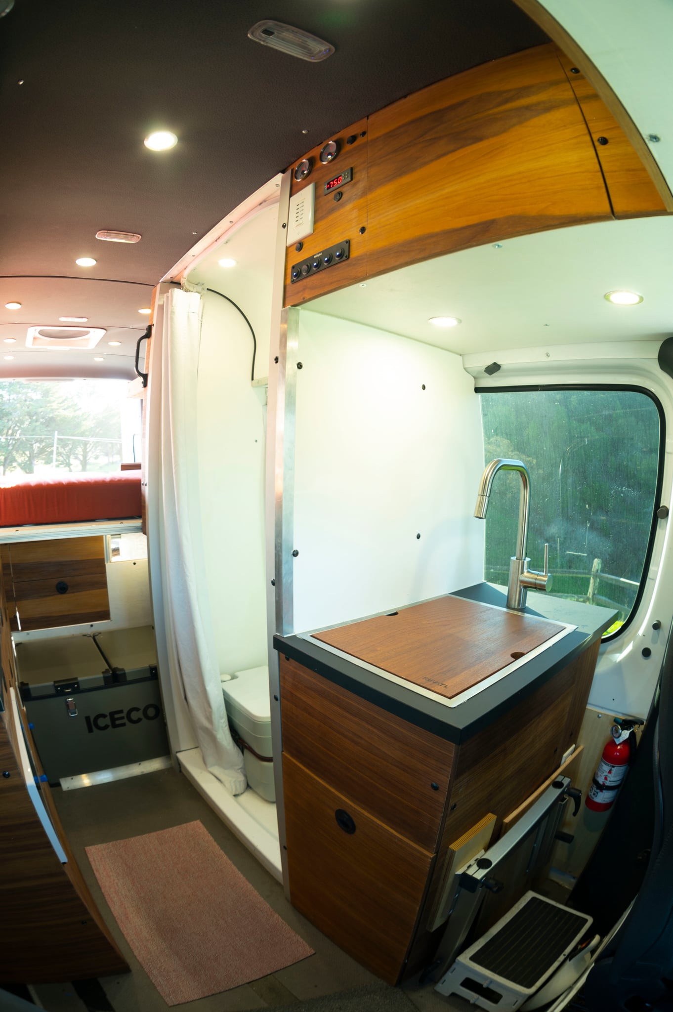 and a wooden control panel on the left.|Spacious RV rental interior featuring swivel front seats — photo 15