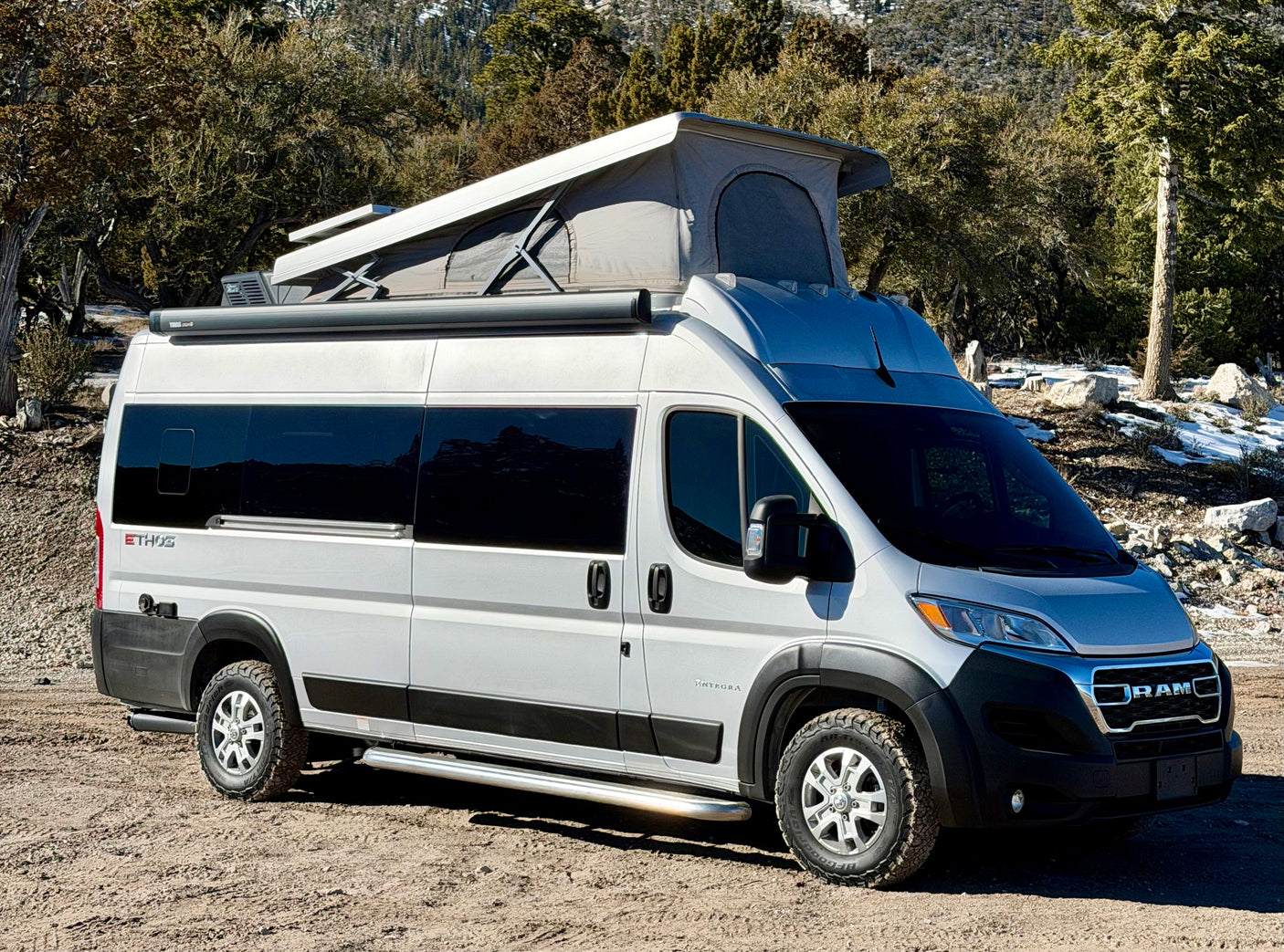 This adventure-ready RAM Ethos camper van, featuring a pop-top and off-road tires, is perfect for an RV rental.