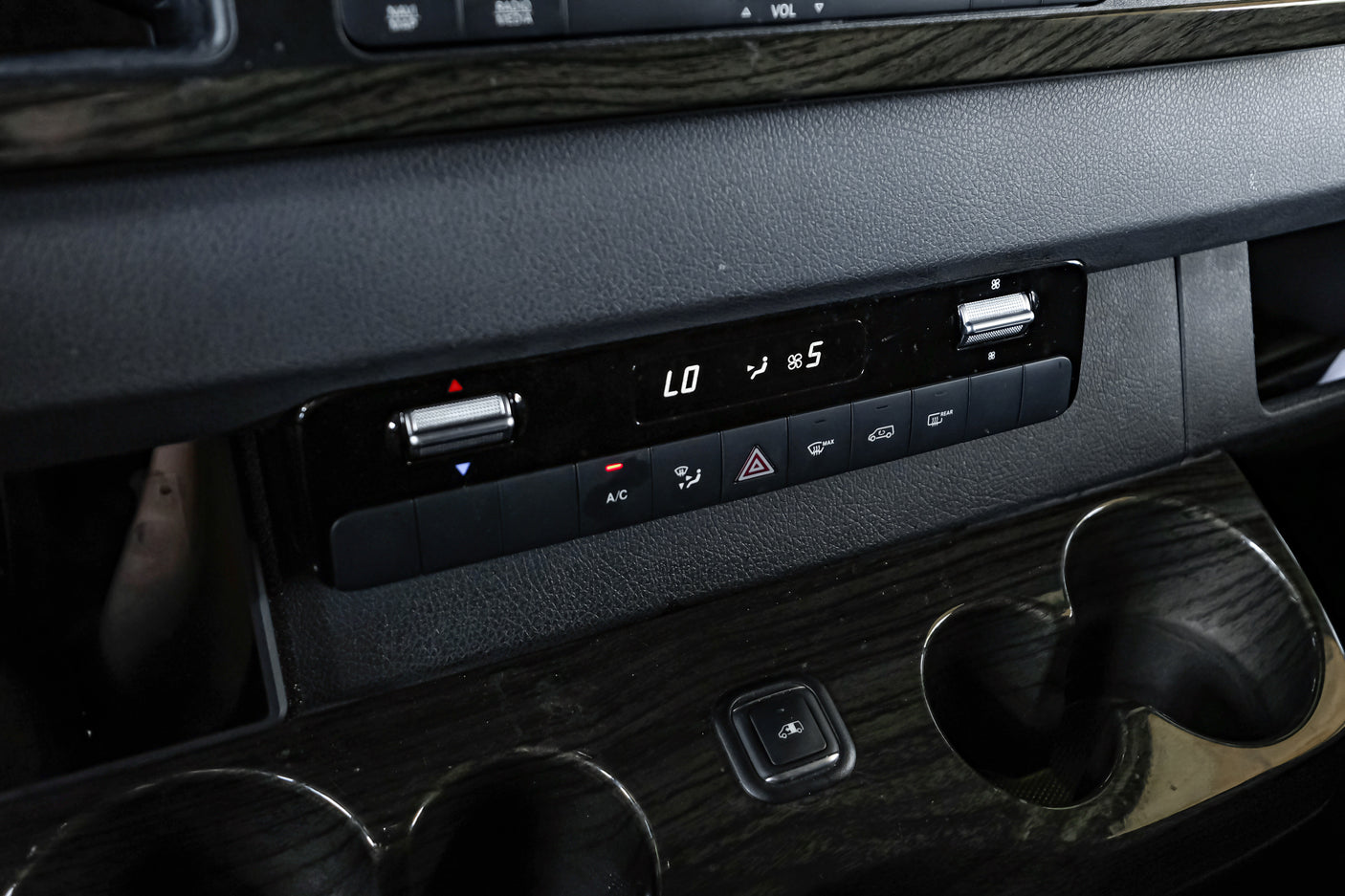 RV rental van's dashboard: Climate control panel displaying LO temperature and fan speed 5, with cup holders and wood trim.