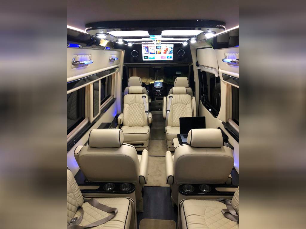 ideal for group travel.|Luxurious RV rental interior: cream captain's chairs