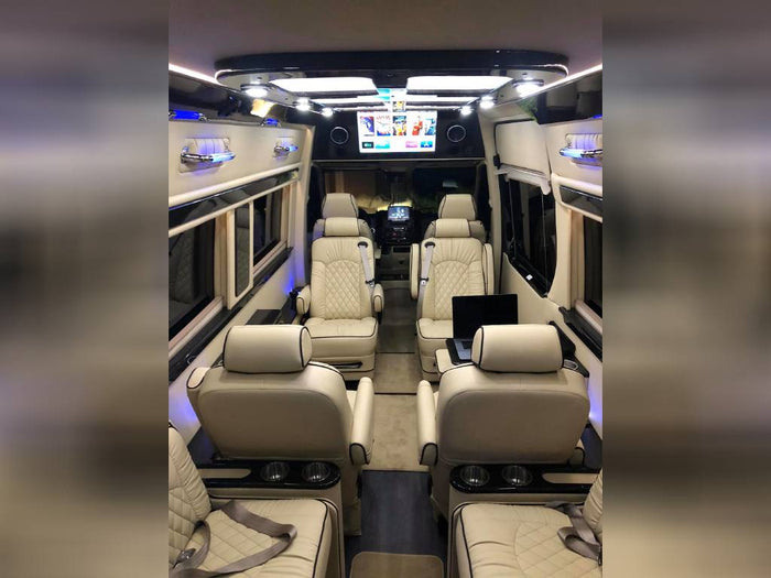 ideal for group travel.|Luxurious RV rental interior: cream captain's chairs