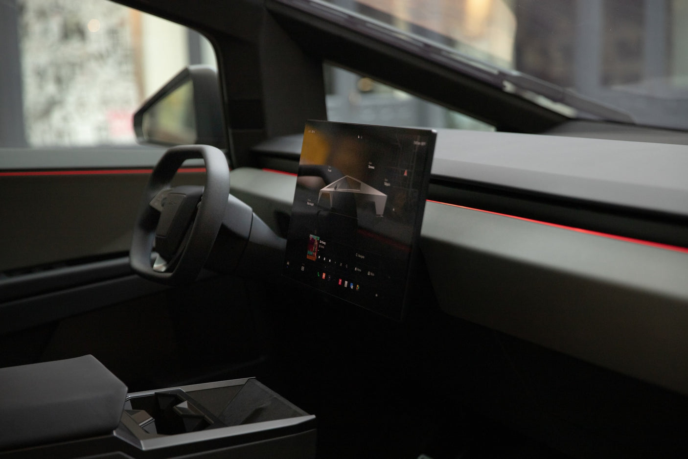 Inside a Tesla Cybertruck: yoke steering, large display, and red accent lighting. Ideal for a unique rv rental adventure.