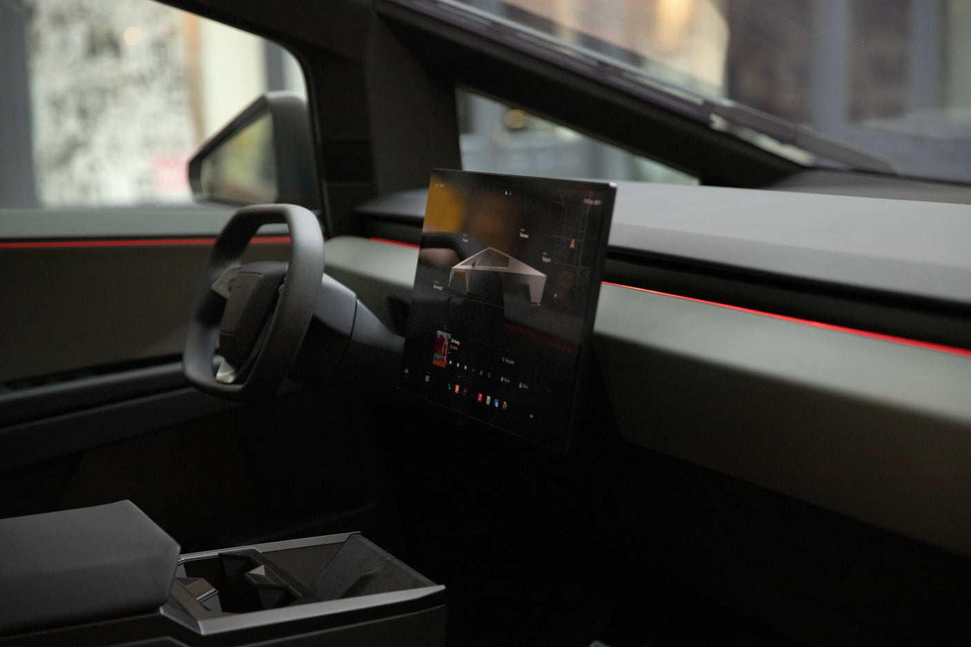 Inside a Tesla Cybertruck: yoke steering, large display, and red accent lighting. Ideal for a unique rv rental adventure.
