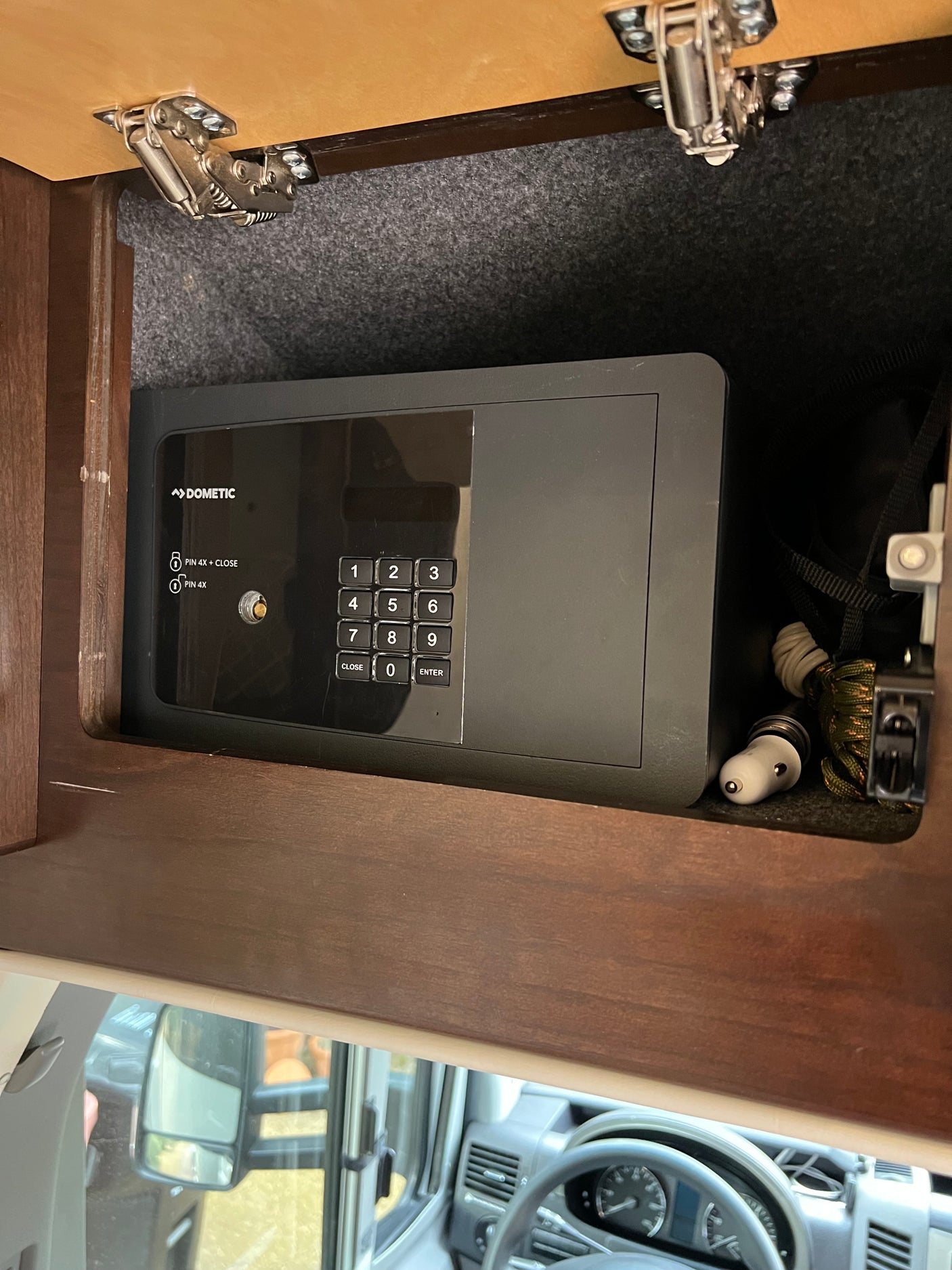 An RV rental interior featuring a Dometic digital keypad safe inside a cabinet, offering secure storage for valuables during travel.