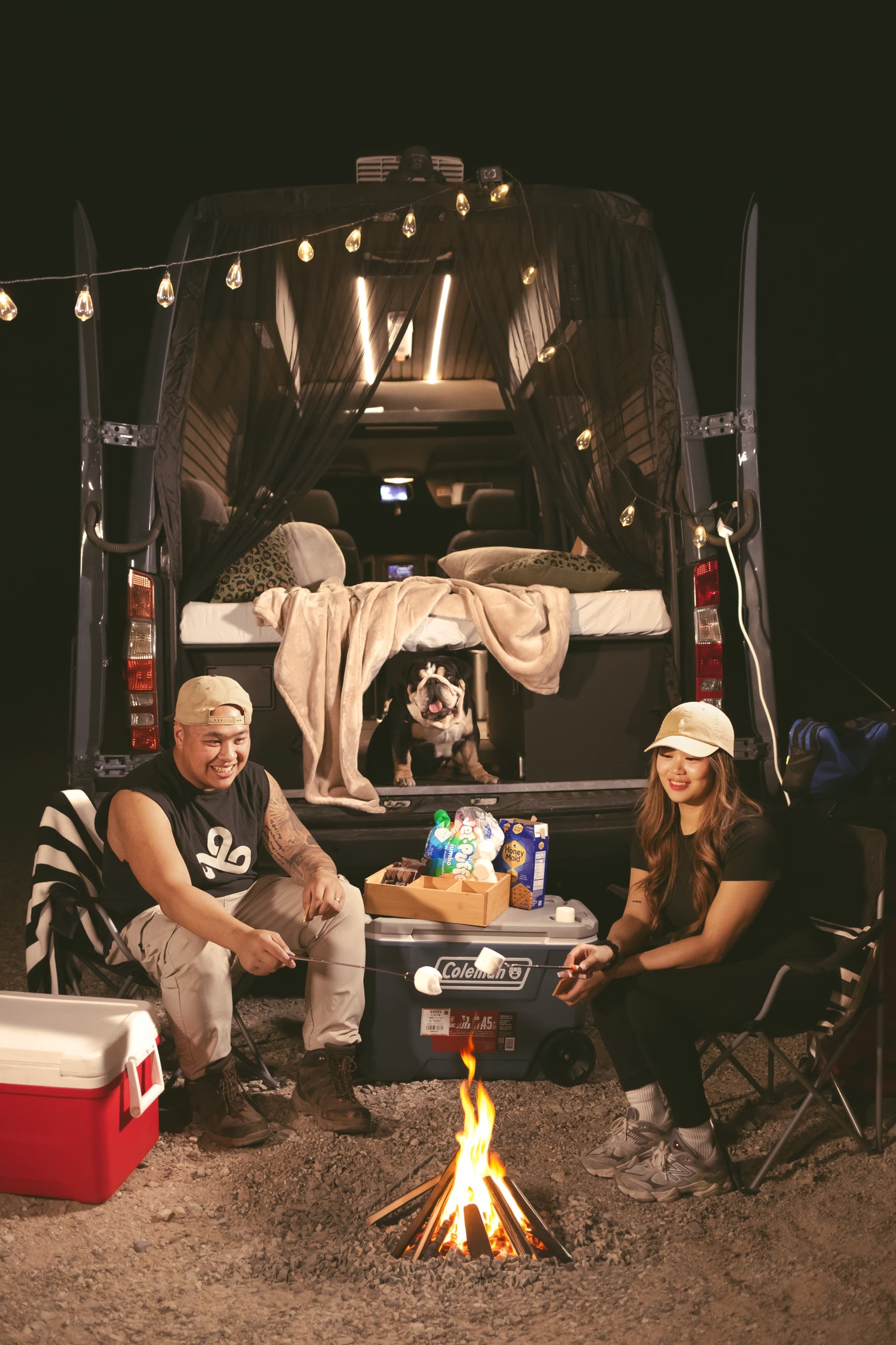 Cozy night with our RV rental, roasting s'mores by the campfire. Our bulldog enjoys the van life adventure!