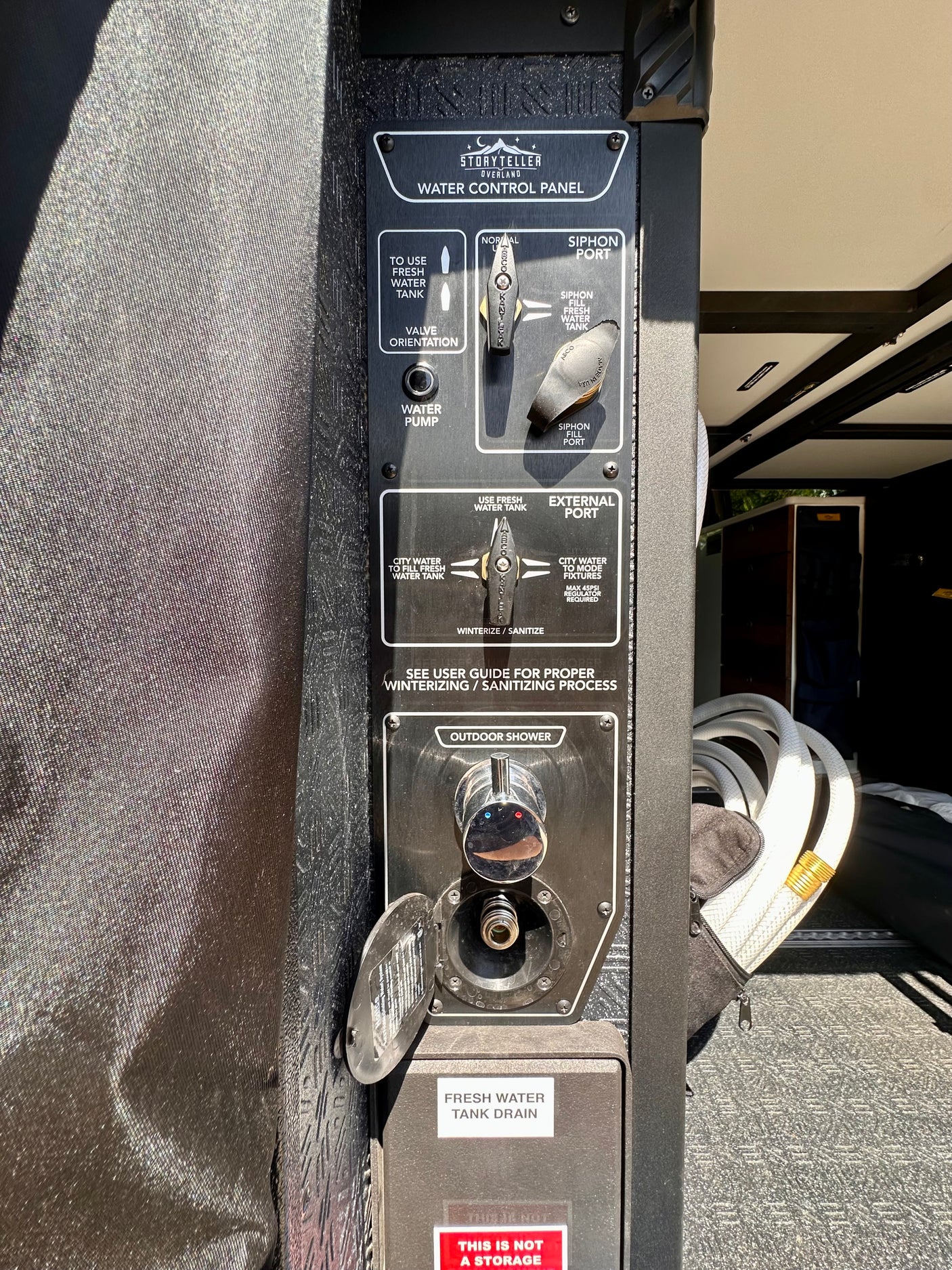 RV rental water control panel by Storyteller Overland, featuring fresh water, city water, siphon, and outdoor shower.