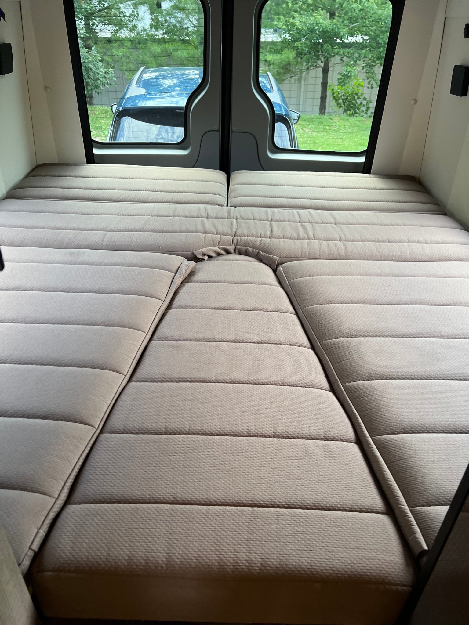 reveals its open side door and cozy interior.|Side view of a modern gray camper van