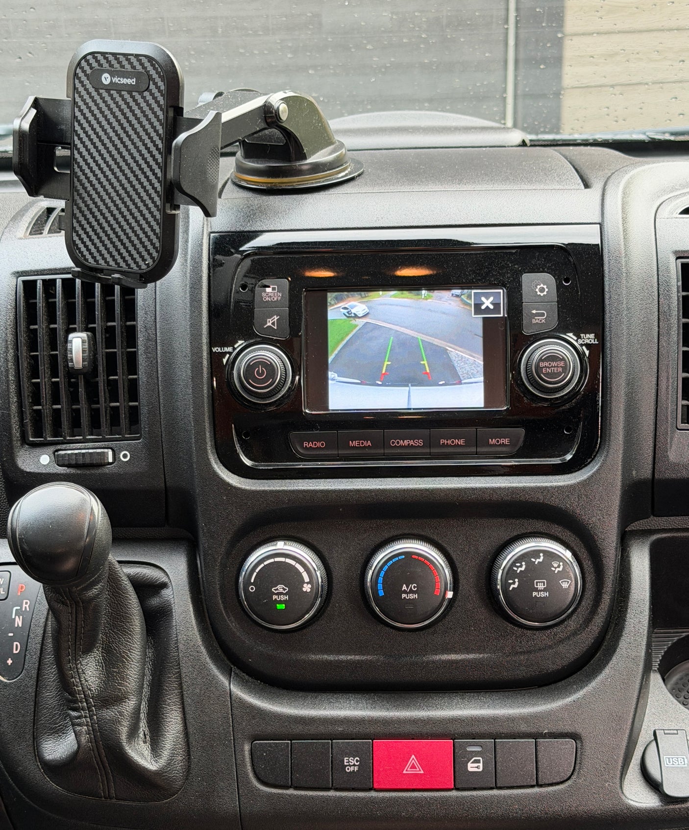RV rental dashboard, showing central screen with backup camera, phone mount, gear shift, and climate controls.