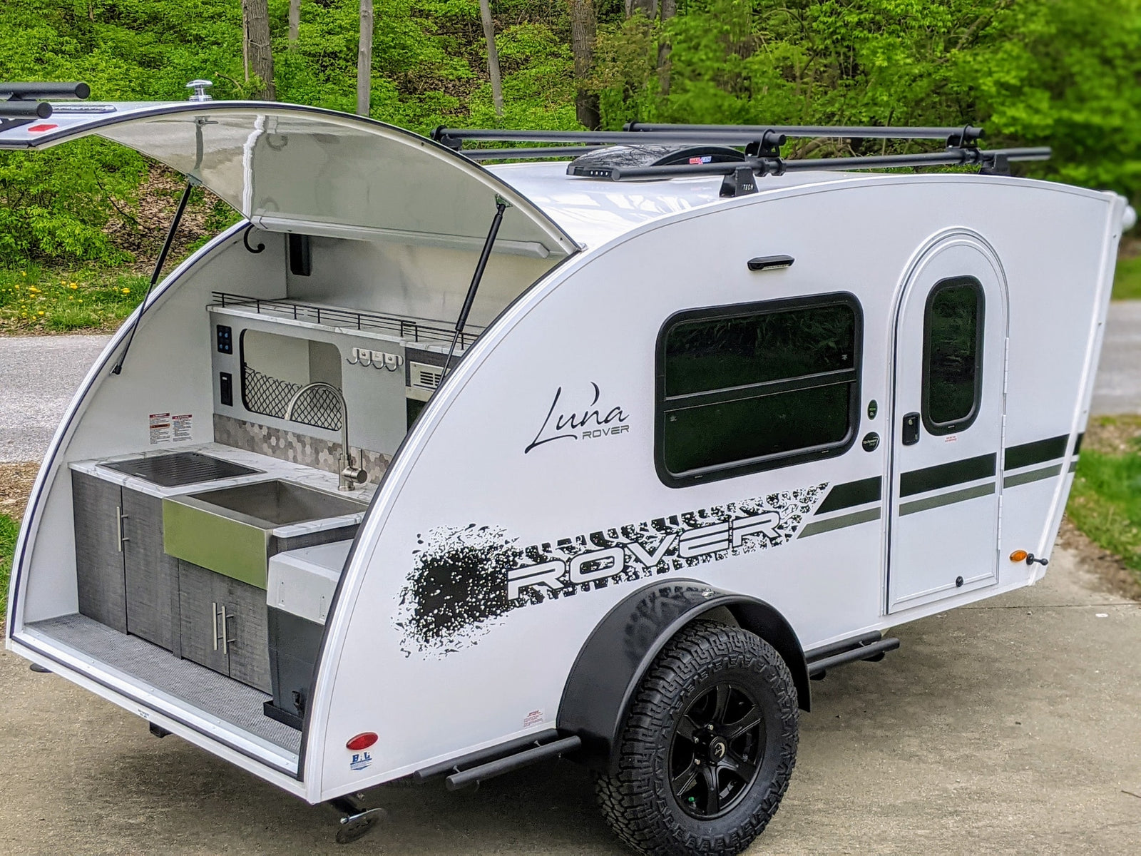 Experience adventure with this Luna Rover teardrop RV rental, featuring an open rear kitchen and rugged tires.