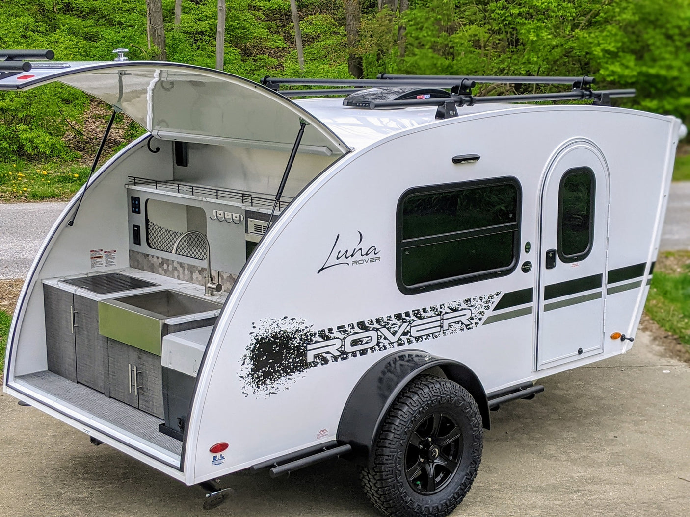 Experience adventure with this Luna Rover teardrop RV rental, featuring an open rear kitchen and rugged tires.