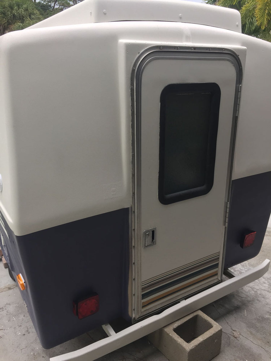 and person setting up by a lake.|Compact rv rental interior with bed