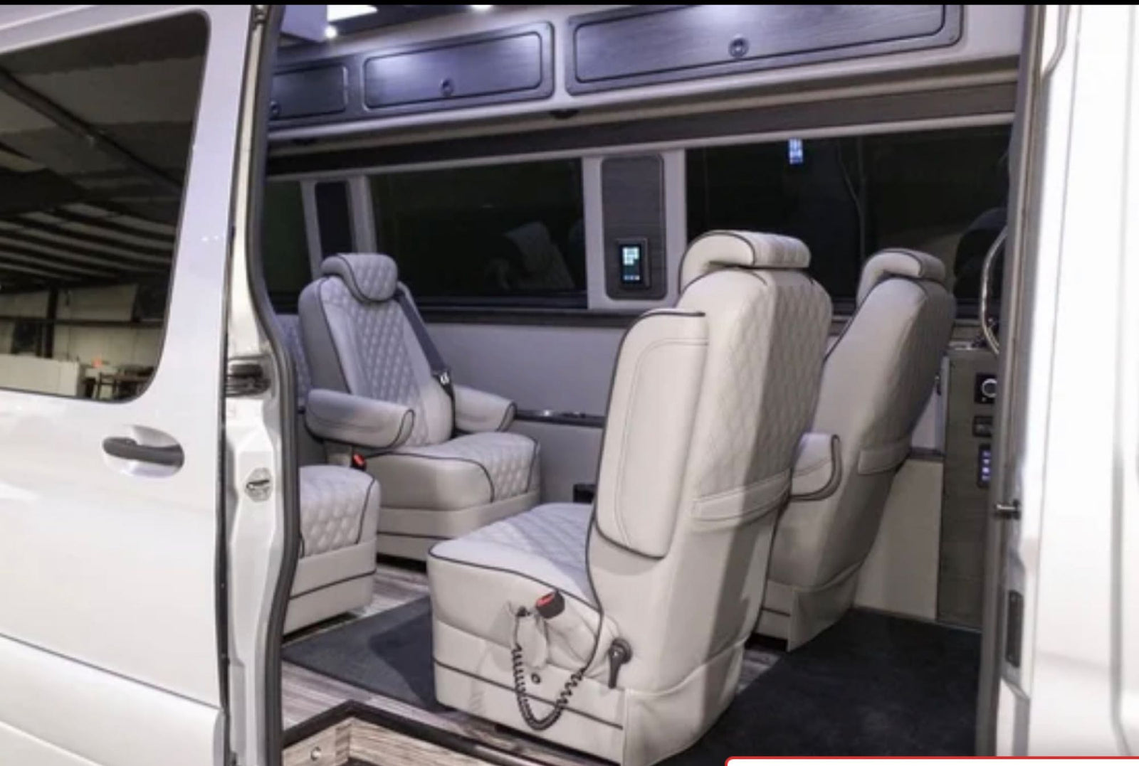 Luxurious custom van interior, perfect for an RV rental. Features premium quilted seating, ample space, and overhead storage.